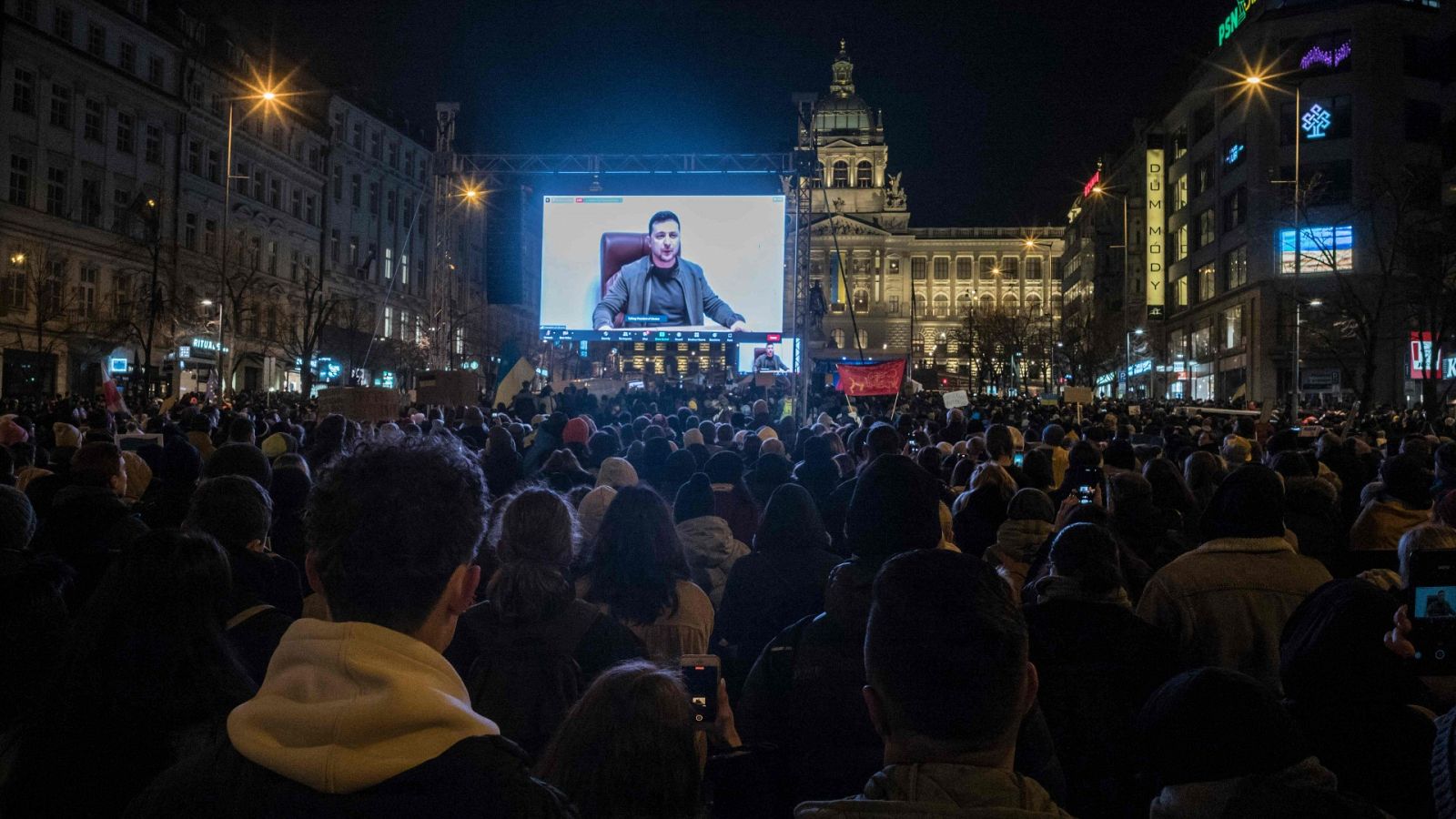 Manifestantes escuchan el discurso de Volodímir Zelenski en la Plaza de Wenceslao, en Praga