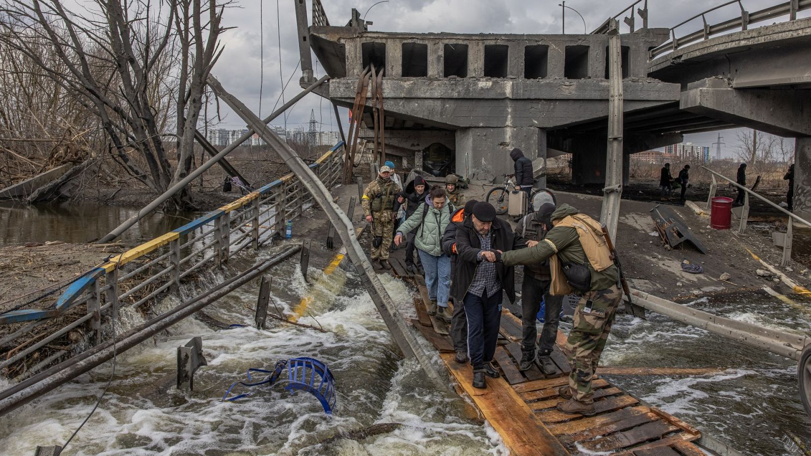 Residentes cruzan un puente destruido mientras huyen de la ciudad de Irpin, Kiev
