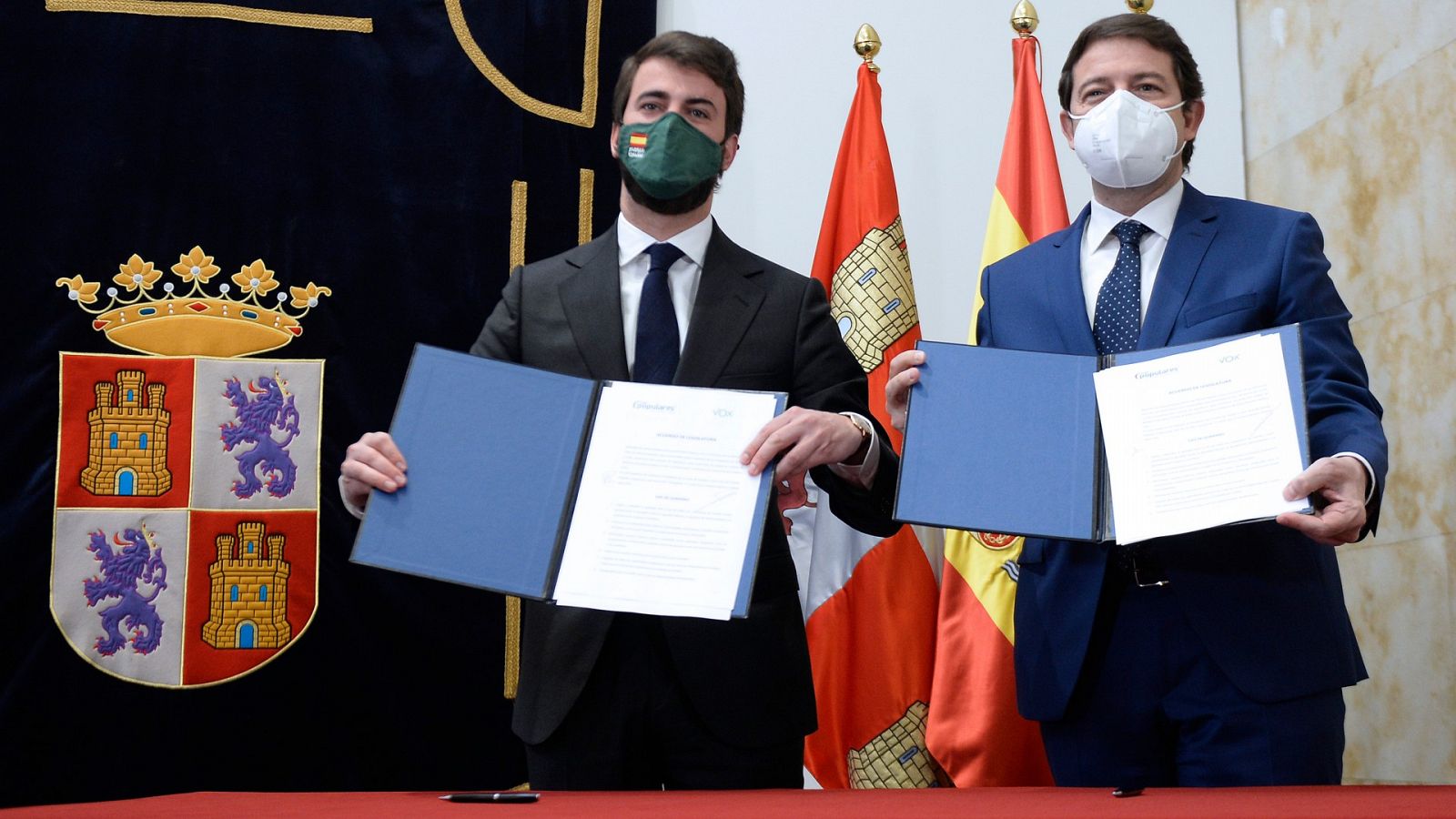 El presidente en funciones de la Junta de Castilla y León, Alfonso Fernández Mañueco (d), y el candidato de Vox a la presidencia, Juan García-Gallardo (i), muestran el pacto de gobernabilidad.