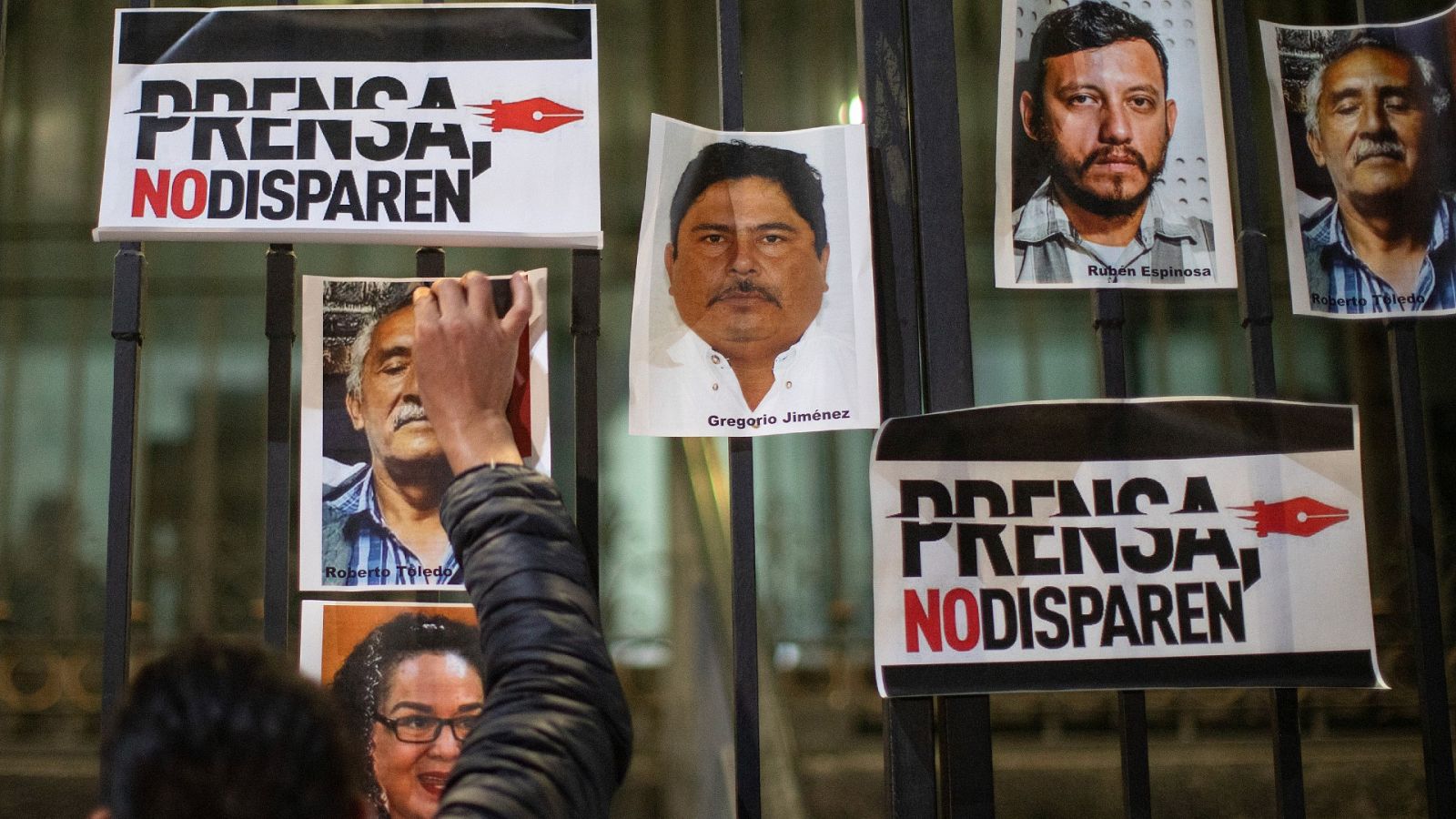 Un periodista pega una fotografía en el exterior de la Secretaria de Gobernación durante una protesta en México