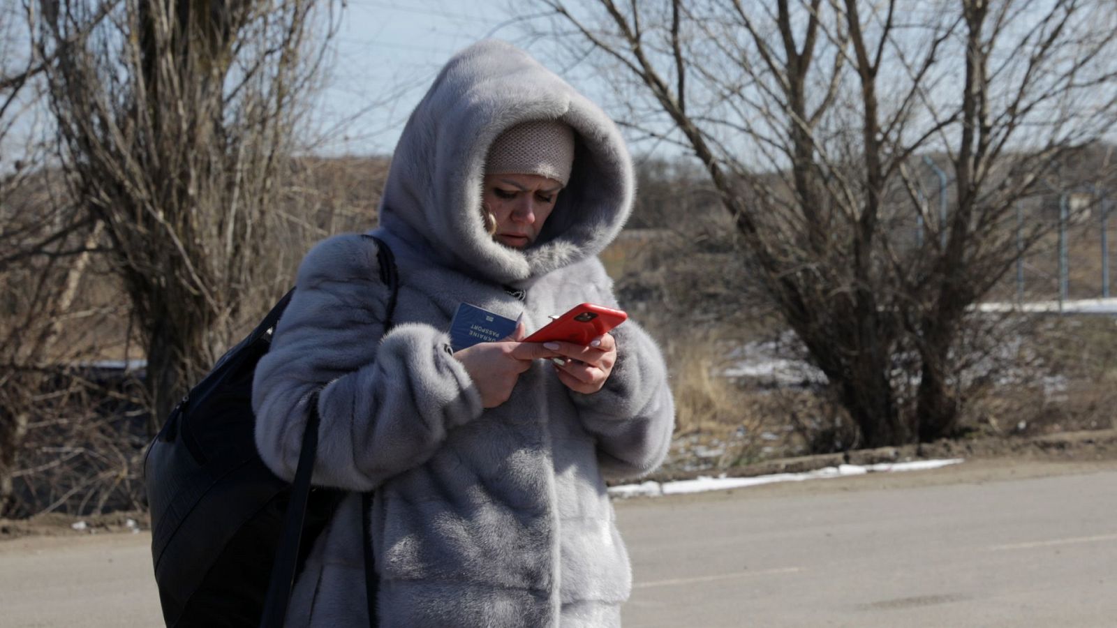 Una mujer utiliza su teléfono en la frontera entre Ucrania y Moldavia