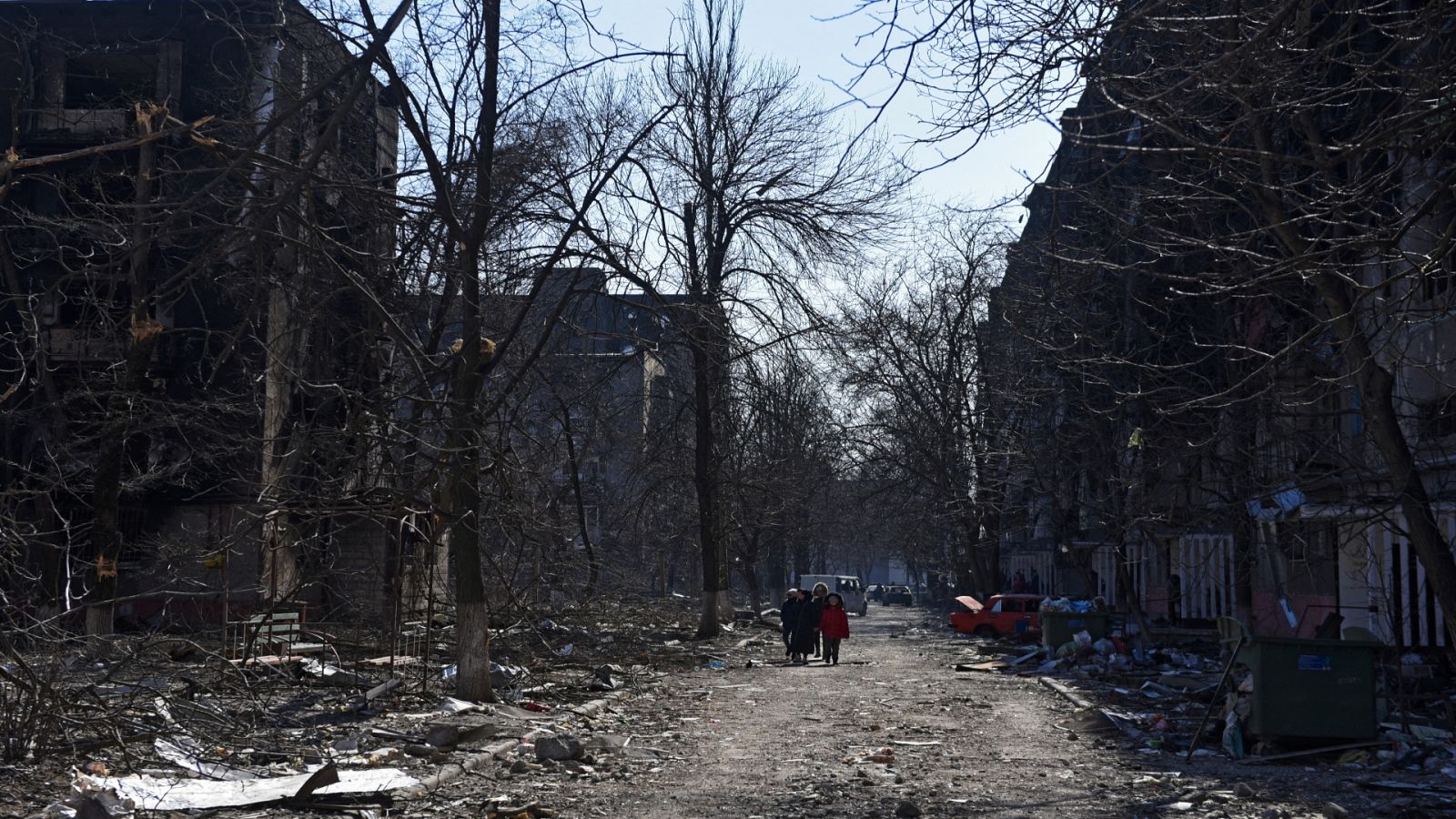 Residentes locales caminan cerca de los edificios en Mariúpol, Ucrania. 