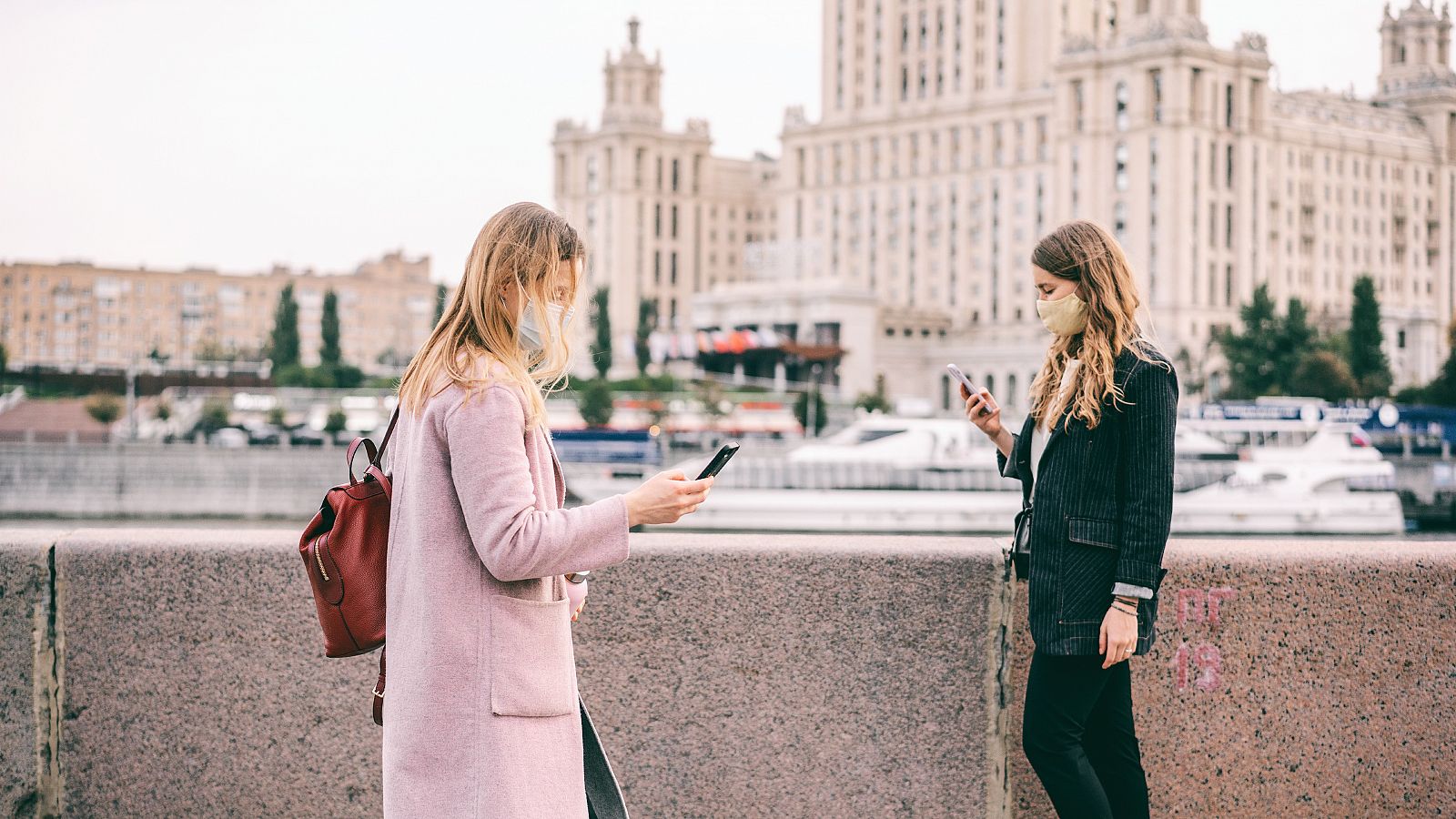 Dos mujeres caminan por Moscú con su teléfono inteligente en la mano.