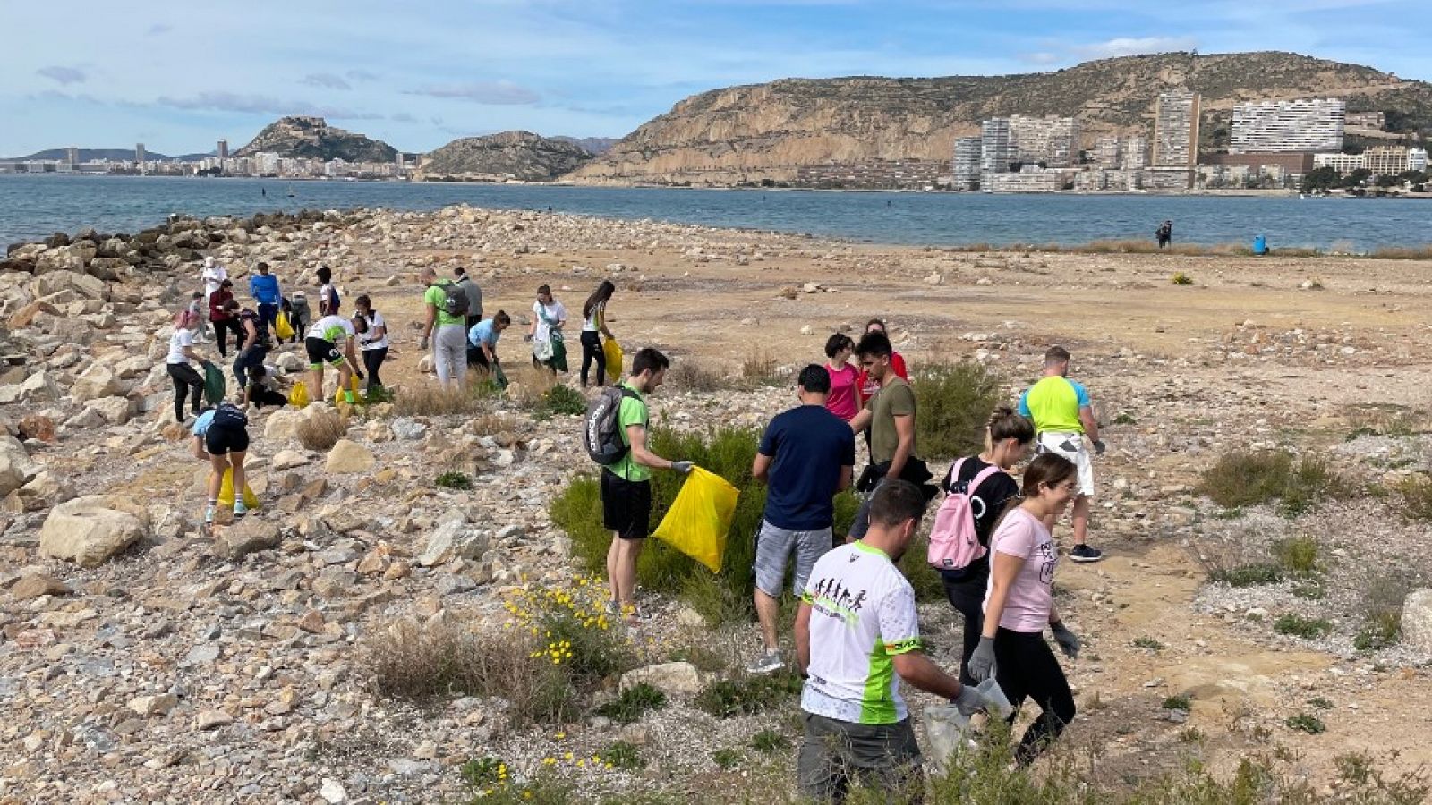 Un grupo de personas recoge basura en la costa mediterránea.