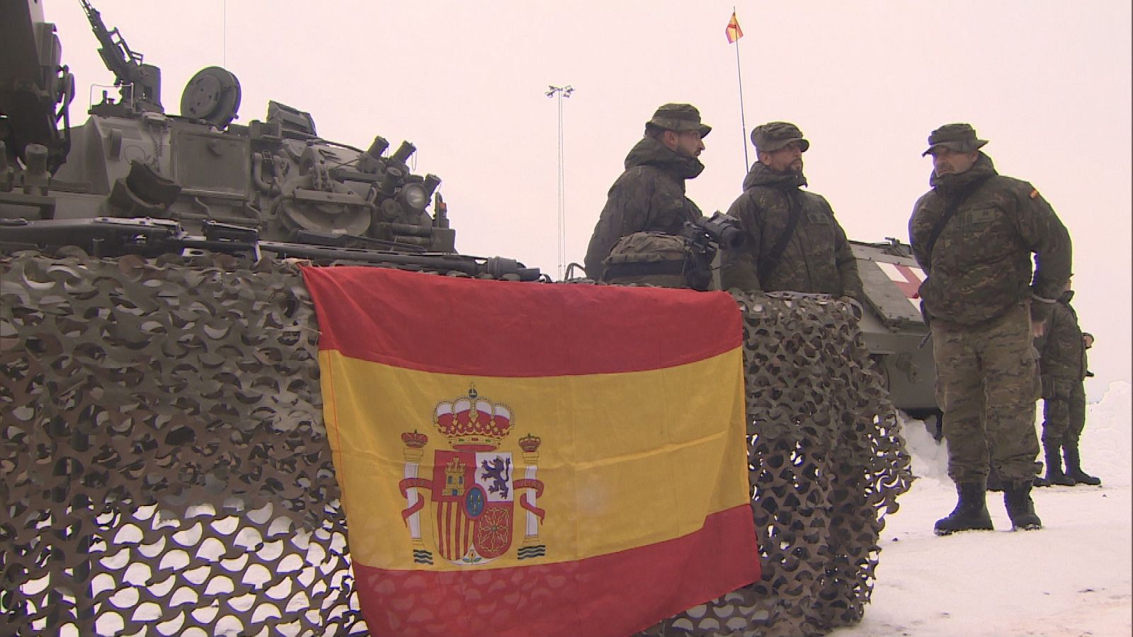 Militares españoles con una bandera nacional durante las maniobras sobre la nieve de Noruega.