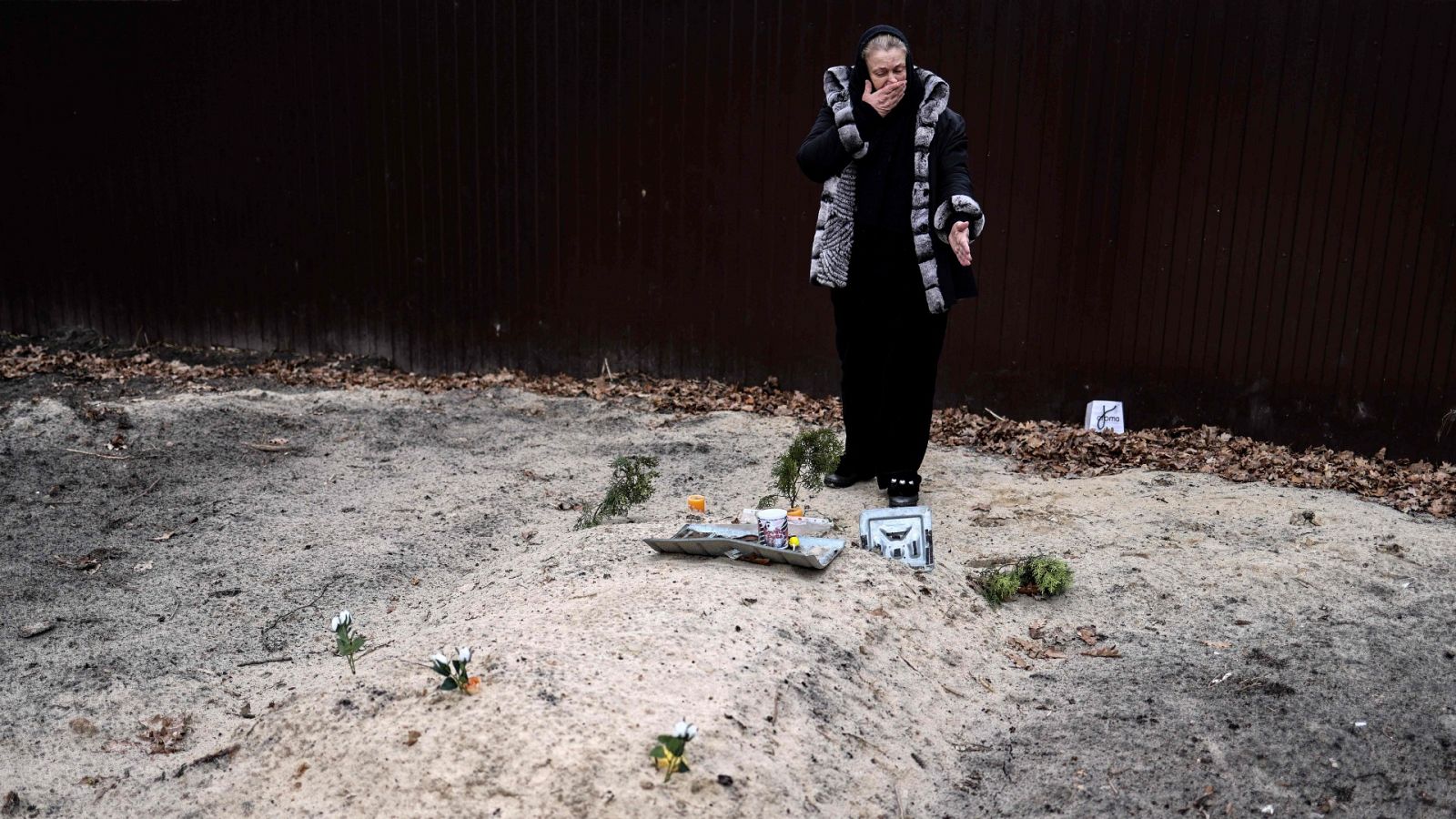Tetiana Ustymenko, residente en Bucha, llora sobre la tumba de su hijo, enterrado en el jardín de su casa, en Bucha, al noroeste de Kiev, el 6 de abril de 2022