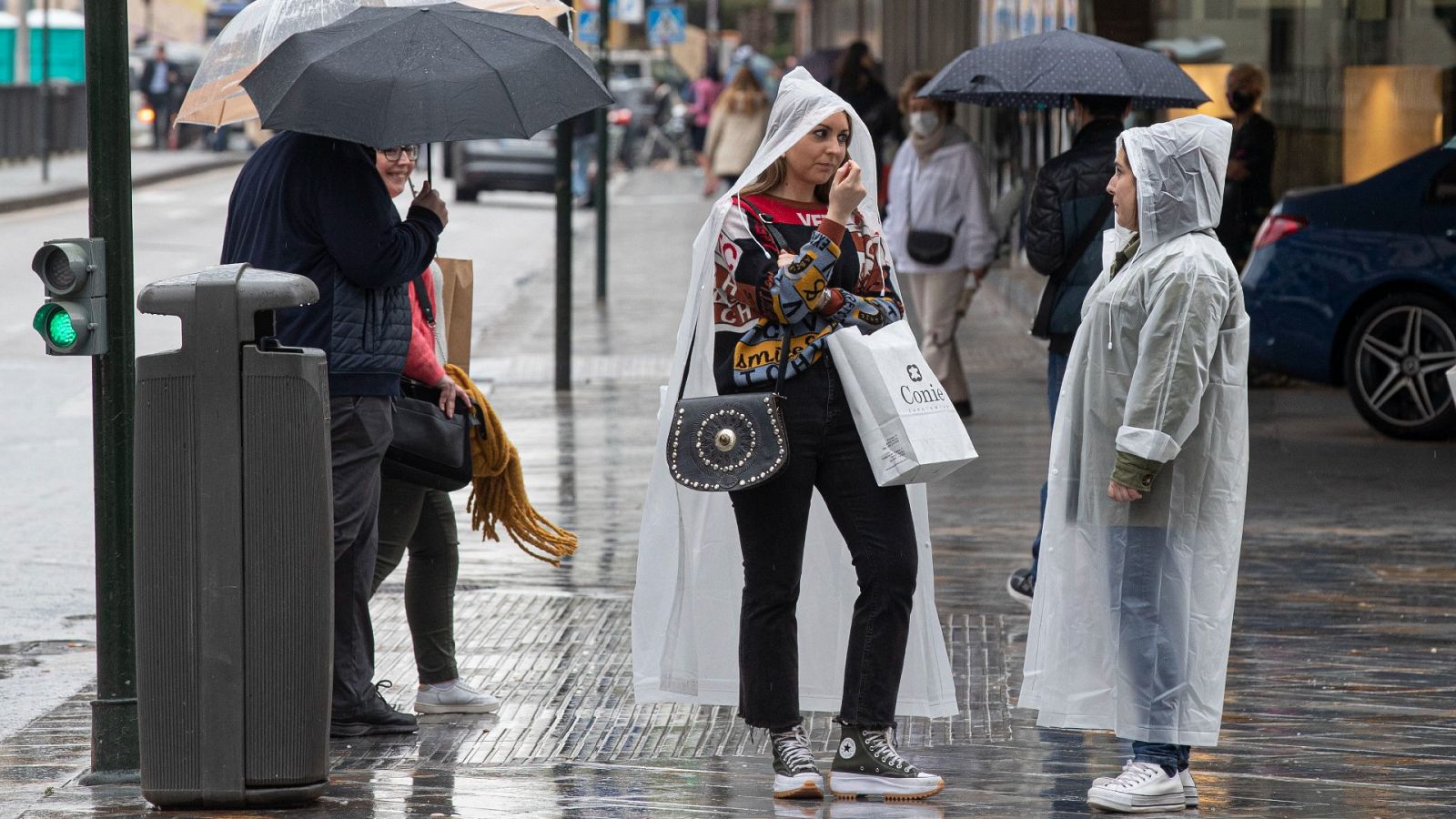 Varias personas se protegen de la lluvia este martes en la Gran Vía de Murcia