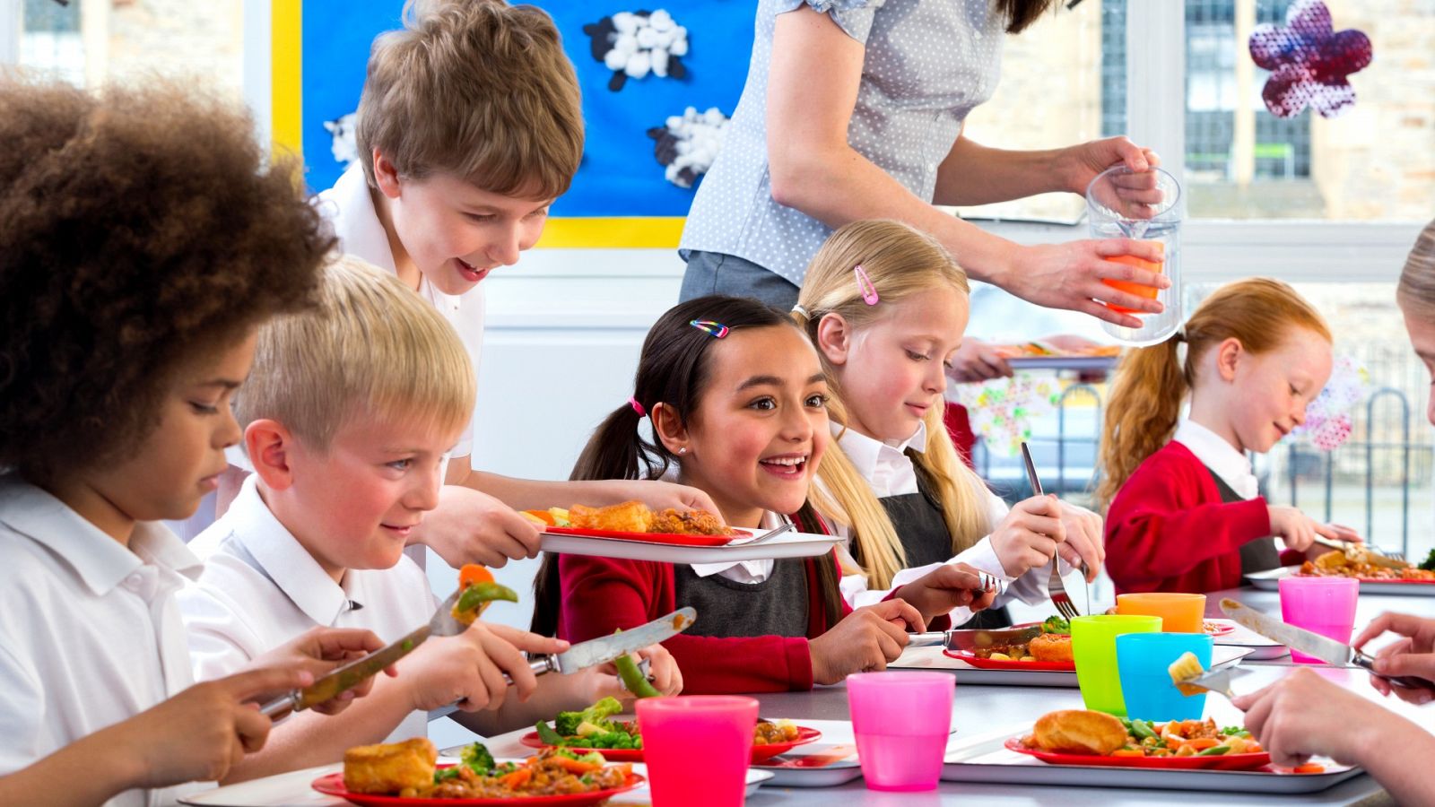 Un grupo de niños almuerza en un comedor escolar