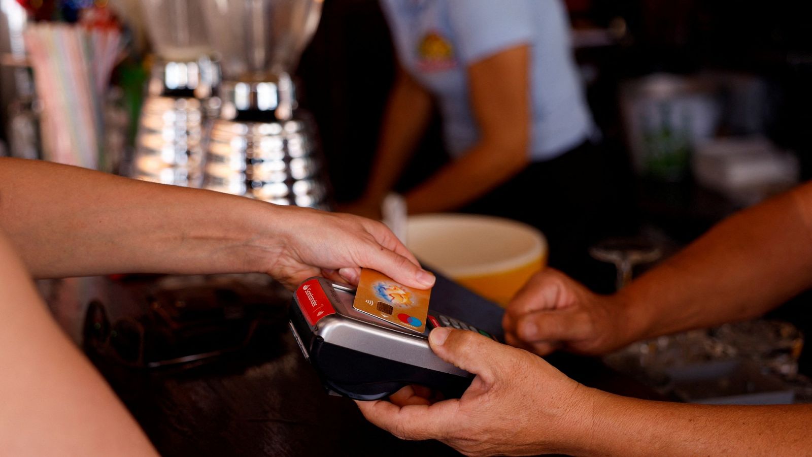 Una mujer paga con tarjeta en un restaurante