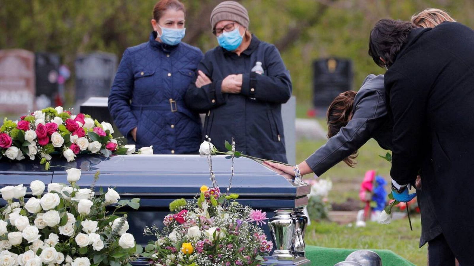 Una mujer toca el ataúd de su esposo, que murió a causa de la enfermedad por coronavirus (COVID-19), en Malden, Massachusetts, EE. UU.