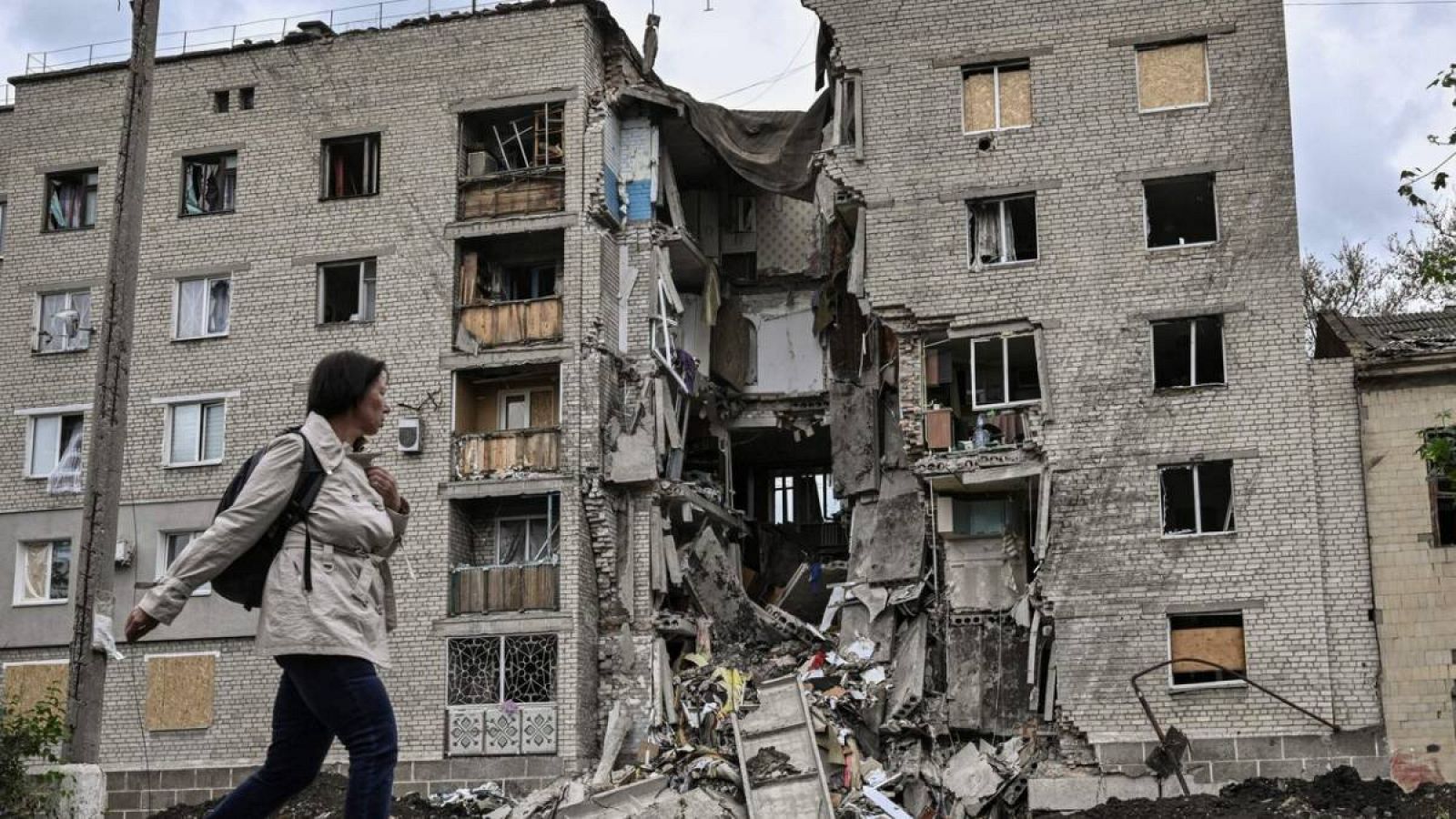 Una mujer camina junto a un edificio de apartamentos destruido en Bakhmut, en la región oriental de Ucrania de Donbás.