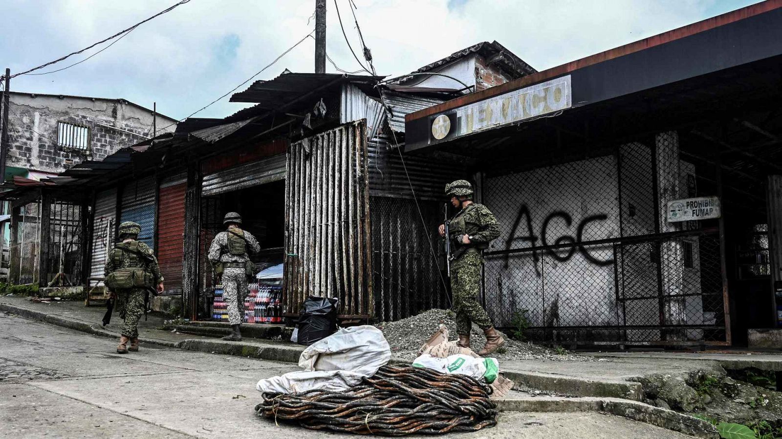 Soldados colombianos fotografiados junto a un grafiti de las AGC Autodefensas Gaitanistas de Colombia