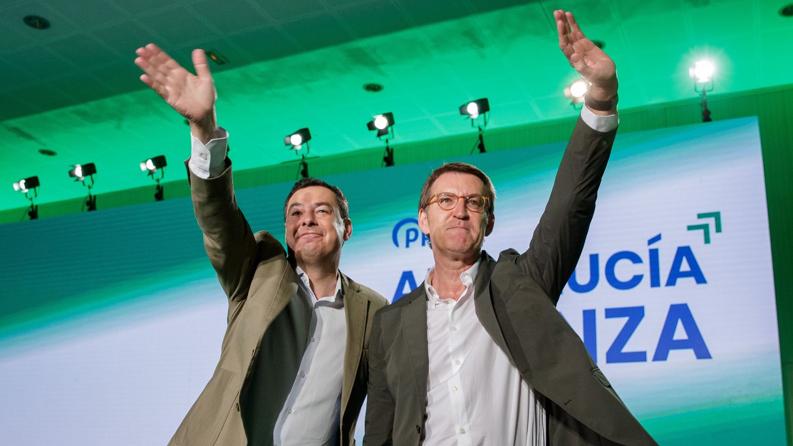 El presidente de la Junta de Andalucía y candidato a la reelección, Juan Manuel Moreno, y el líder del PP, Alberto Núñez Feijóo, saludan a los asistentes a un acto en Sevilla.