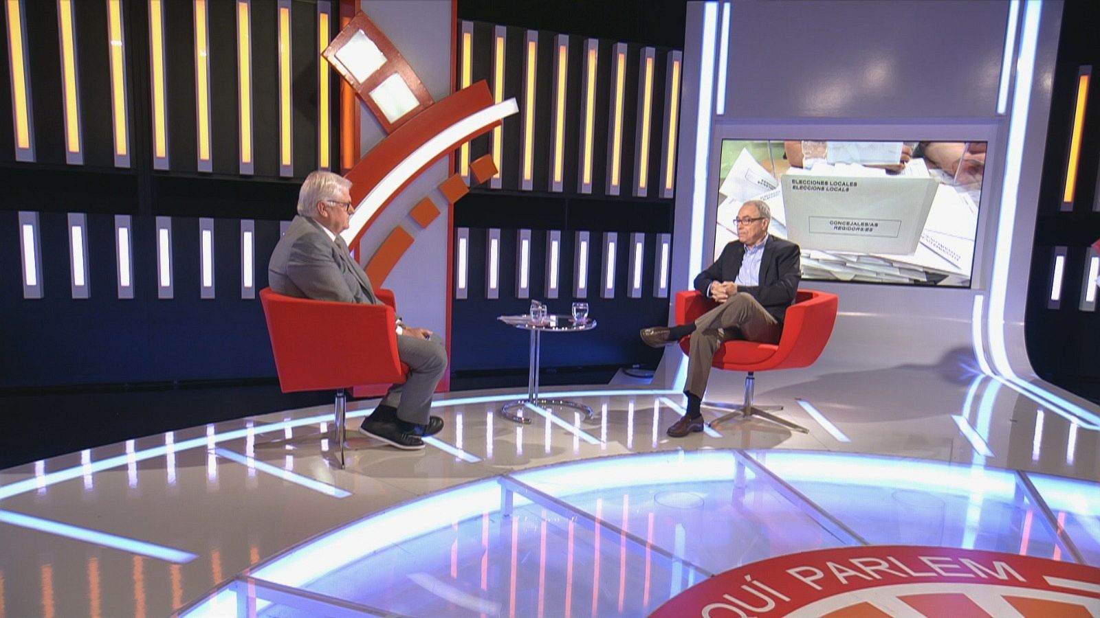Lluís Falgàs i Carles Castro asseguts a les butaques vermelles del plató de l''Aquí Parlem'
