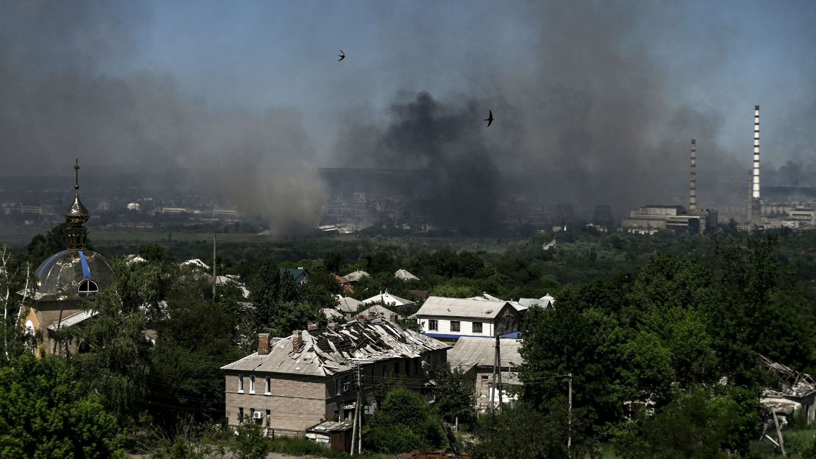 Edificios dañados en la ciudad de Lisichansk. Al fondo, el humo se eleva sobre la ciudad cerca de Severodonetsk, ambas en la región de Donetsk, este de Ucrania. Foto: ARIS MESSINIS / AFP
