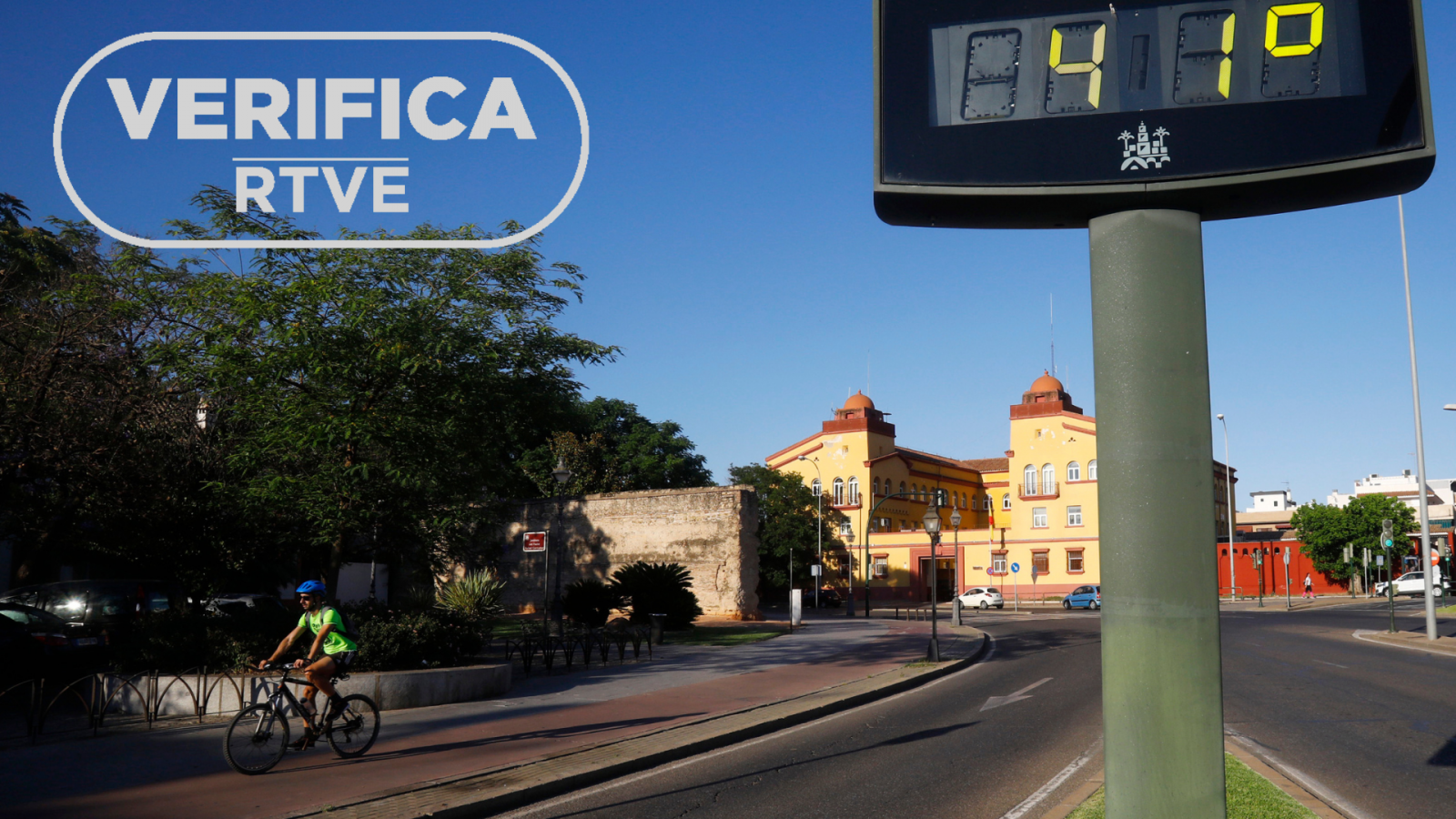 Imagen de la agencia EFE donde un ciclista pasa junto a un termómetro que marca 41 grados en Córdoba, con el sello VerificaRTVE en blanco