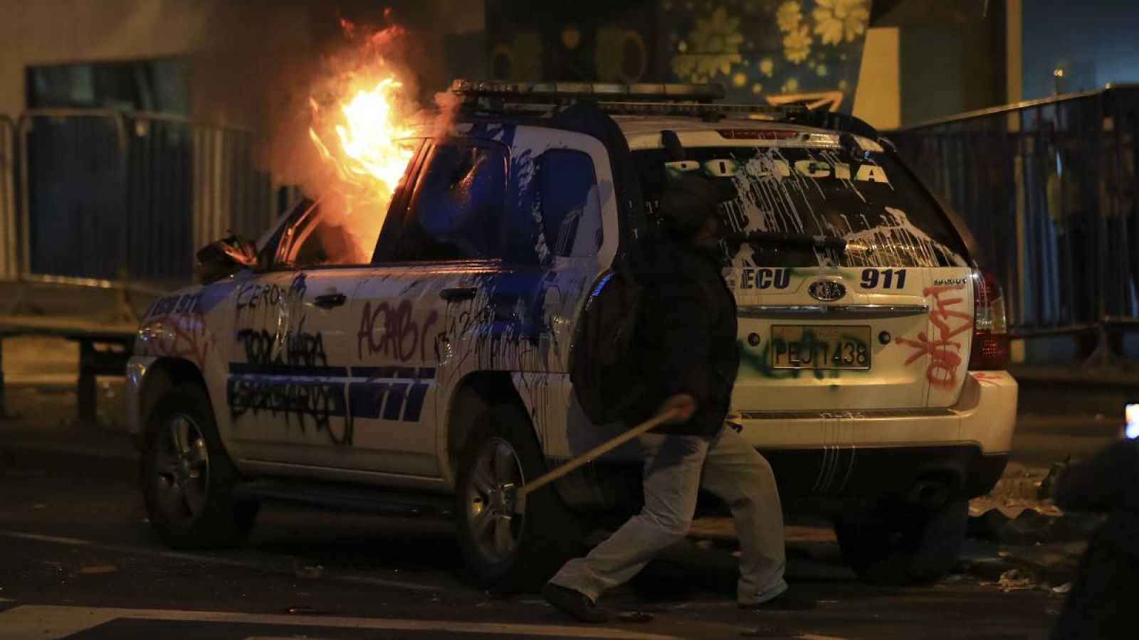 Jóvenes arremeten contra un coche de Policía durante protestas contra el Gobierno de Guillermo Lasso, en Quito (Ecuador). 