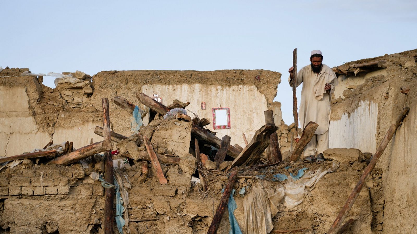 Un hombre rodeado de escombros en la ciudad de Gayan, en Afganistán