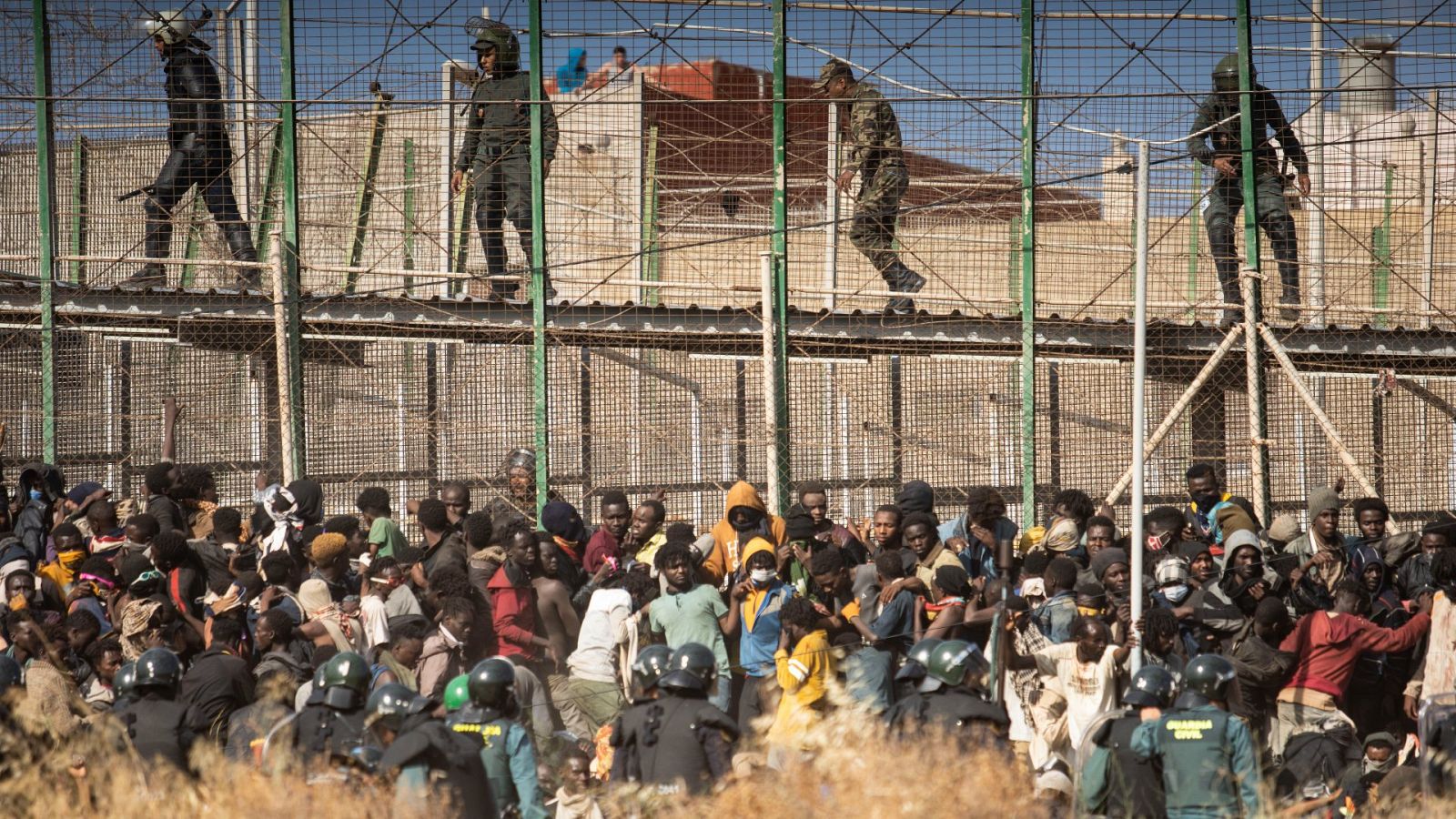 Agentes antidisturbios acordonan la zona tras la llegada de migrantes a España tras saltar la valla de Melilla