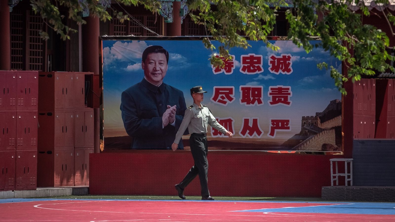 Un soldado chino pasa frente a un cartel del presidente del país, Xi Jinping