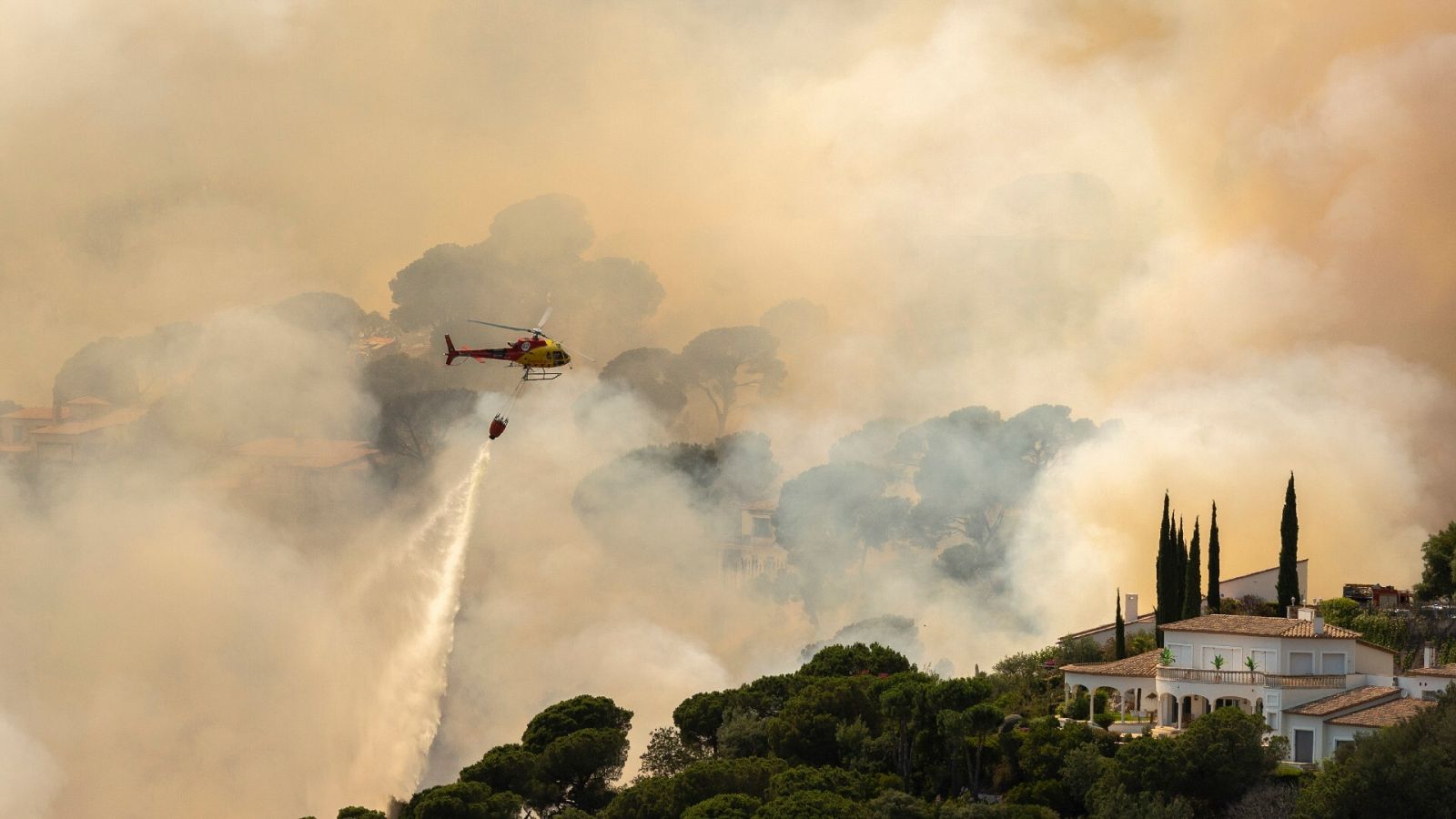 Un helicóptero trata de sofocar las llamas en Santa Cristina d'Aro