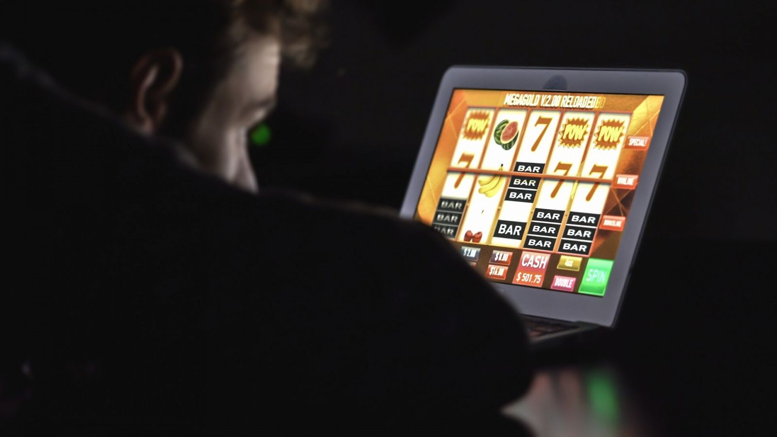 Un joven utiliza el ordenador para jugar a juegos de azar