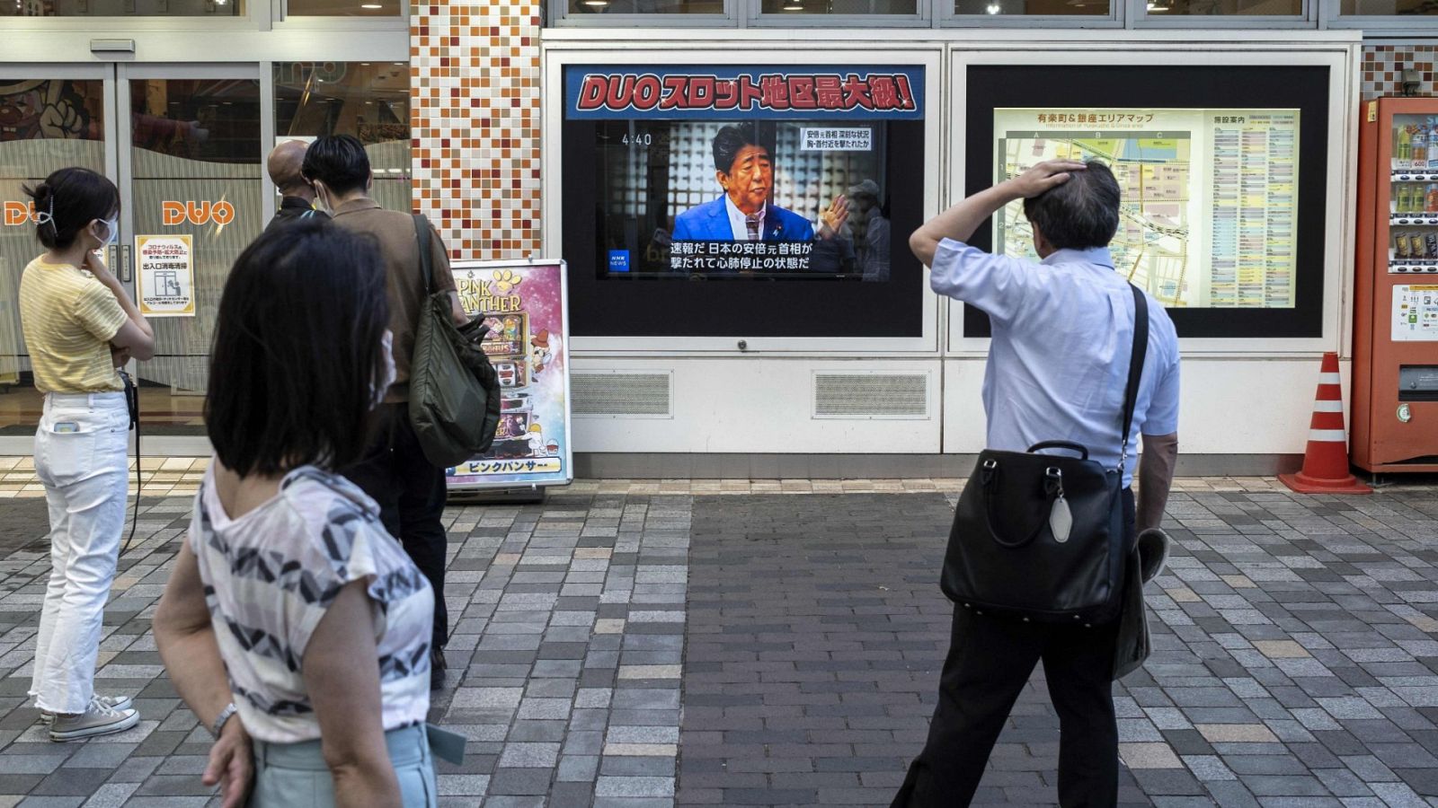 Varias personas observan en una televisión la noticia del asesinato del ex primer ministro japonés, Shinzo Abe