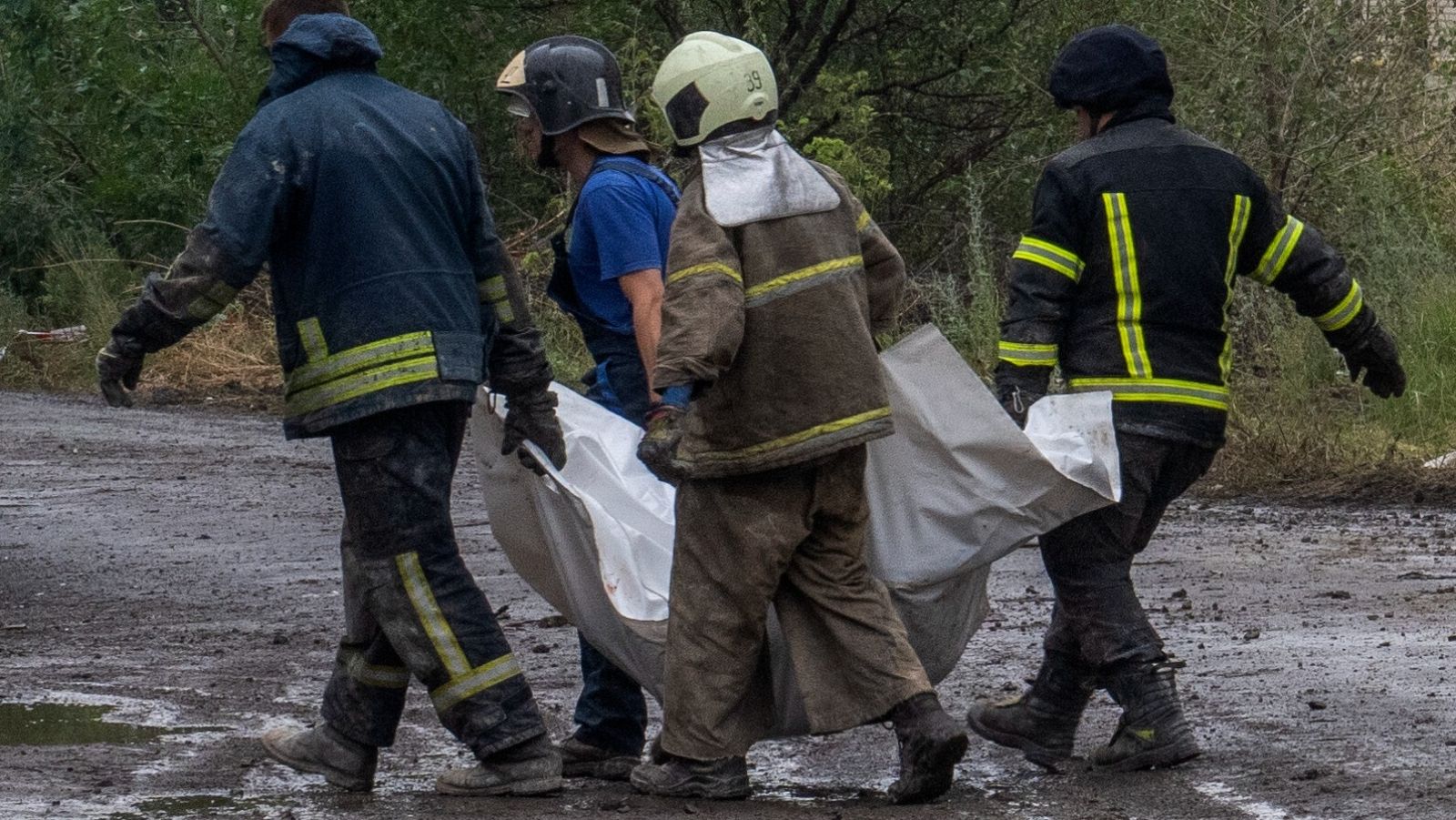 Trabajadores de emergencia ucranianos llevan el cuerpo sin vida de una víctima encontrada bajo los escombros en Chasiv Yar, región de Donetsk