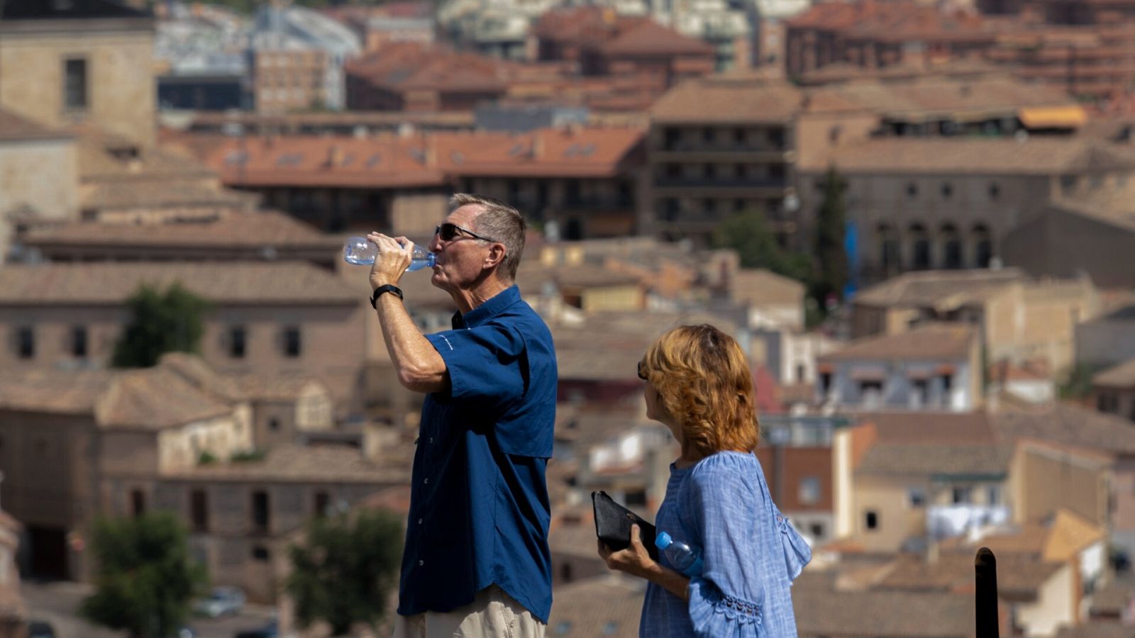 Dos personas pasean por Toledo con sus botellas de agua para hidratarse