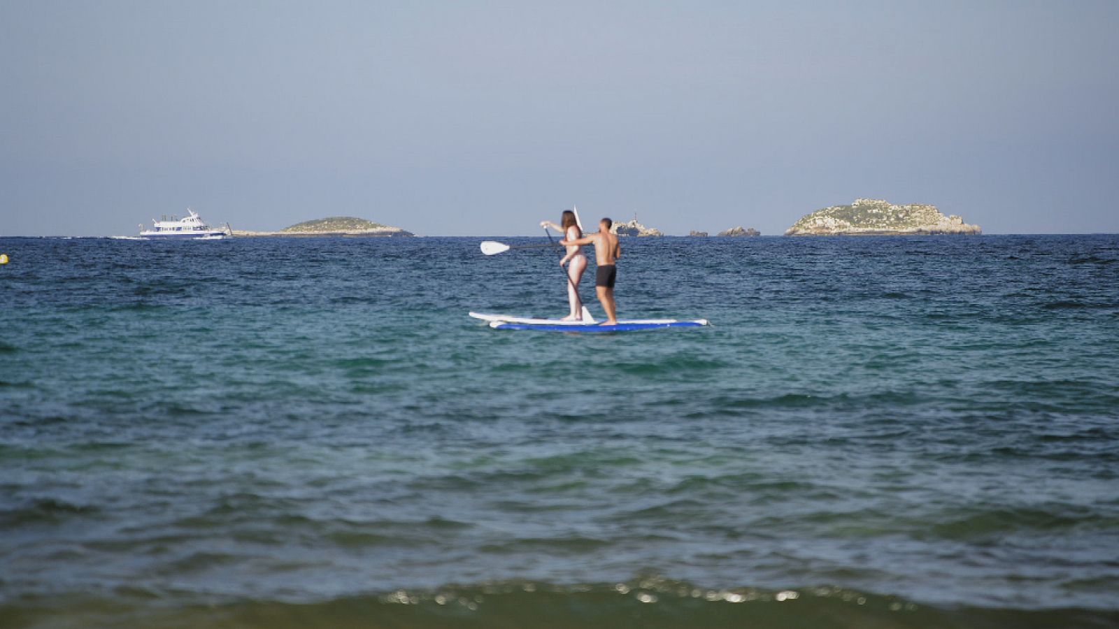 Una pareja hace pádel surf junto a las costas ibicencas