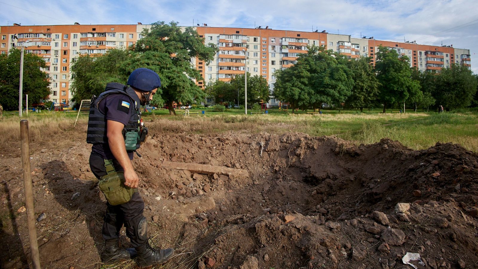 Un policía inspecciona el cráter formado por el impacto de un proyectil ruso