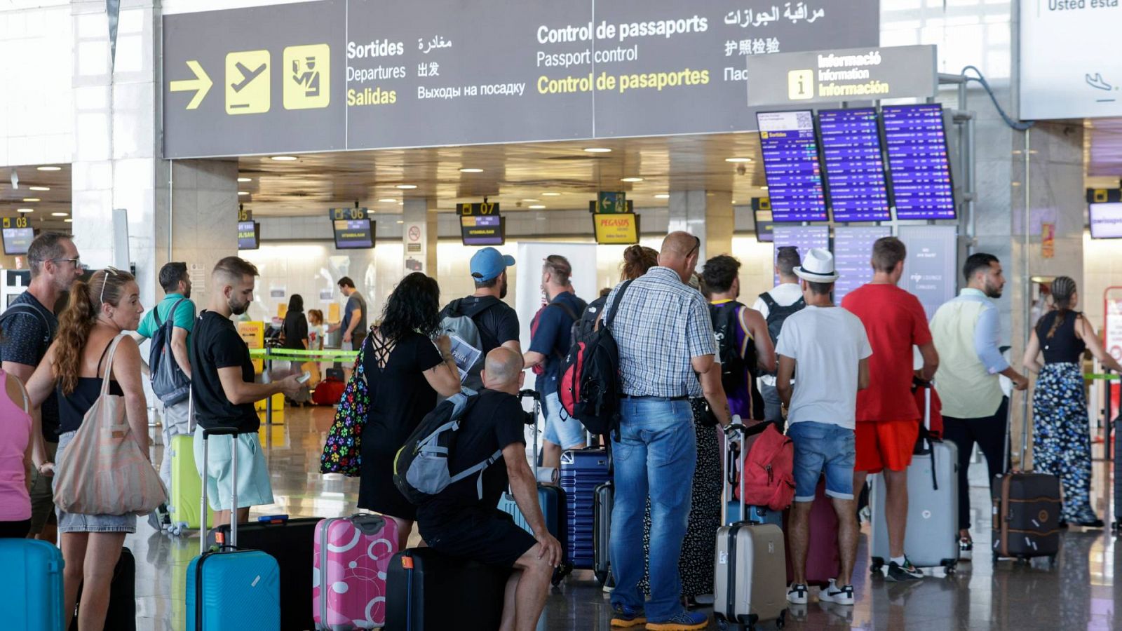 Varios pasajeros hacen cola ante uno de los mostradores de facturación en la Terminal 2 del Aeropuerto de Barcelona-El Prat
