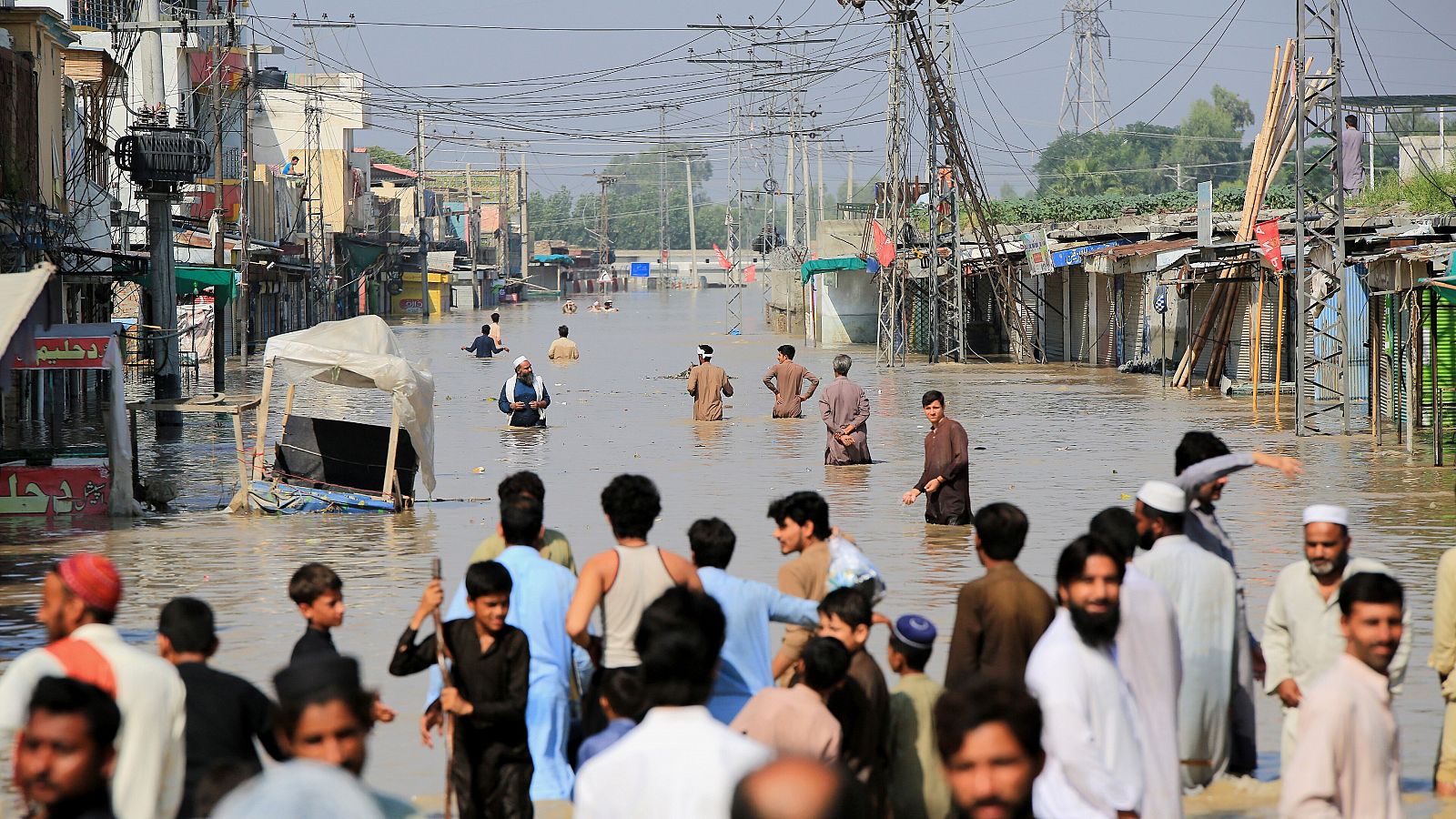 Personas pasean por una zona inundada tras las fuertes lluvias en el distrito de Nowshera, provincia de Khyber Pakhtunkhwa, en Pakistán