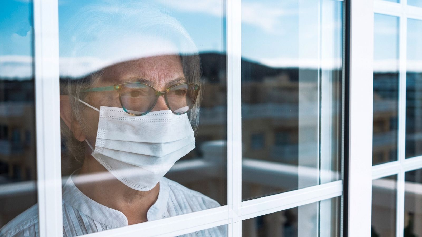 Una mujer con mascarilla permanece confinada en casa por la pandemia de coronavirus, en una imagen de archivo.