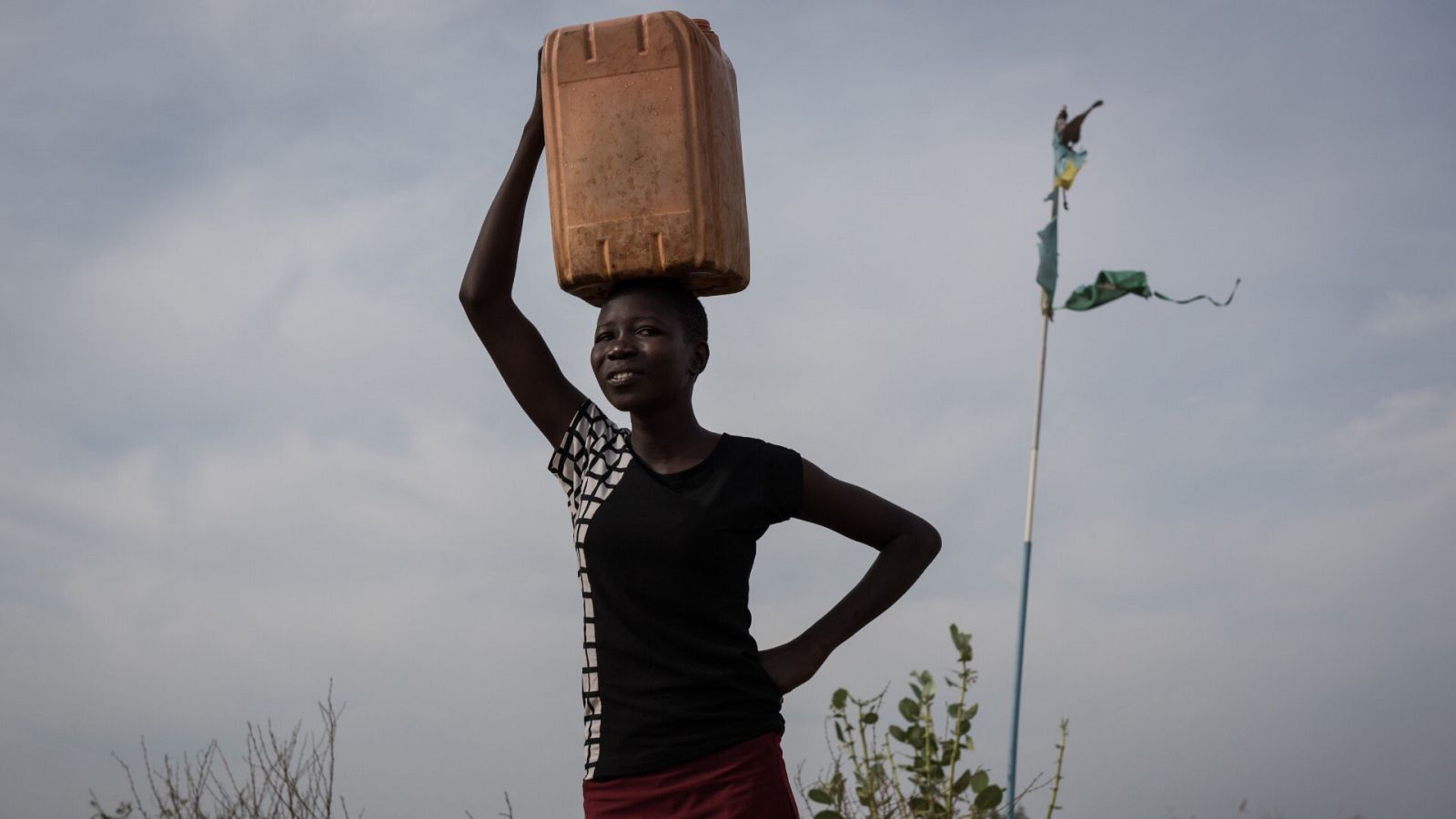 Amal, de diecisiete años, lleva un bidón de agua sin tratar de un grifo en las afueras de Juba en Sudán del Sur