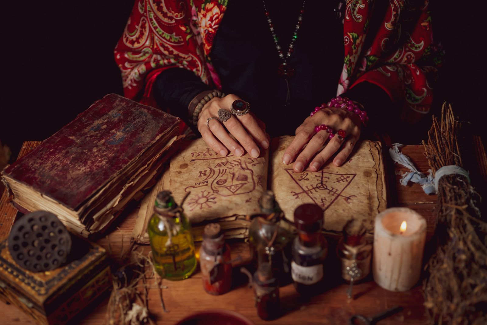 Mujer alquimista mezclando elementos en la mesa de su taller