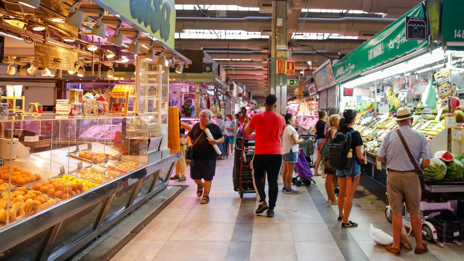 Varias personas hacen la compra en un mercado madrileño