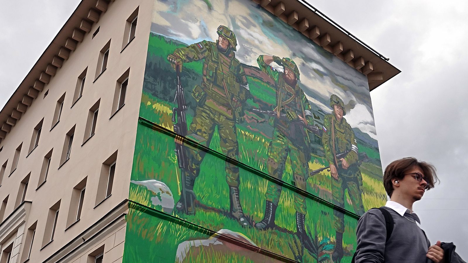 Un ciudadanos pasea delante de un mural de apoyo al ejército ruso