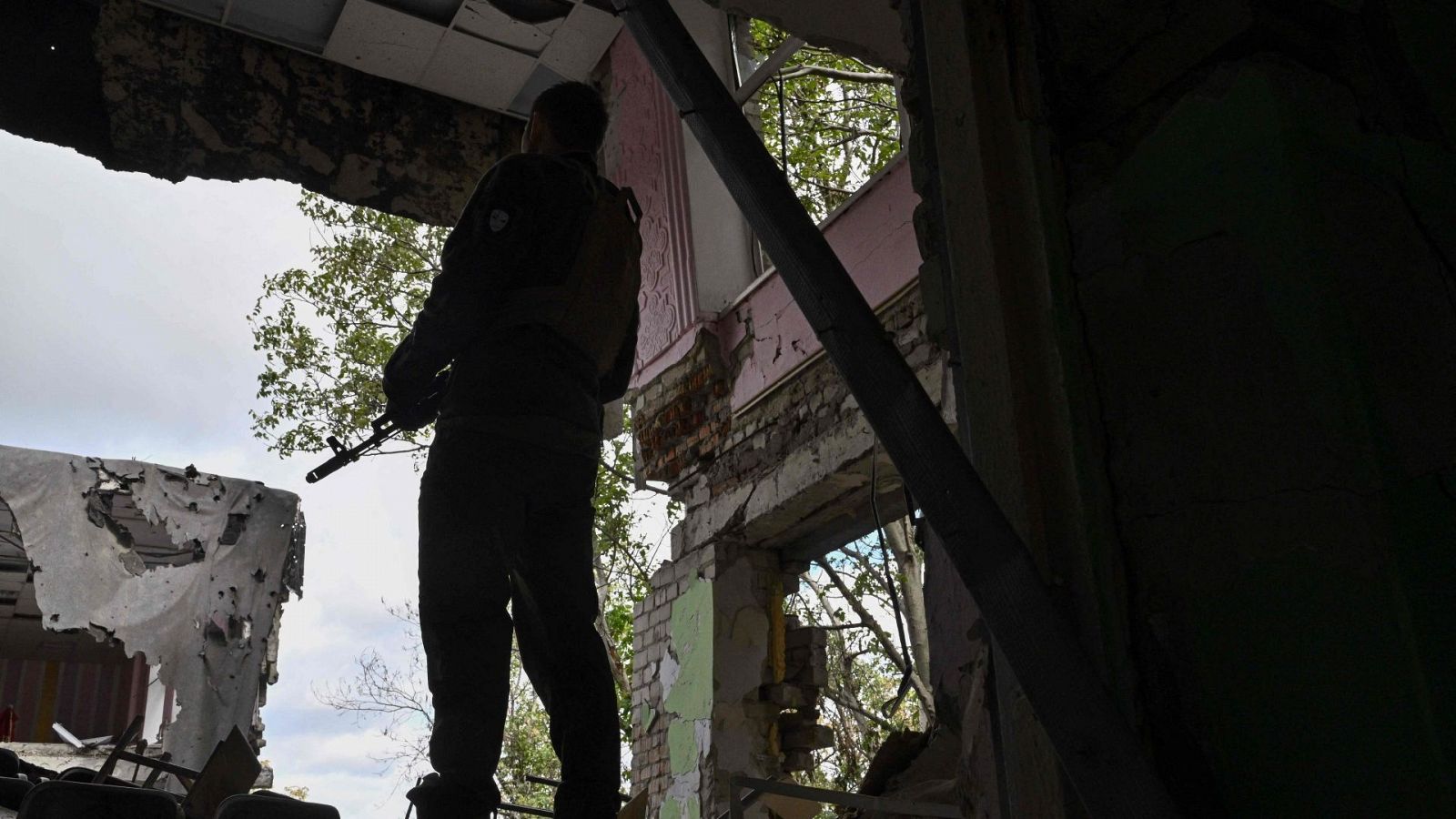 Un militar ucraniano hace guardia en una escuela destrozada en Mykolaiv