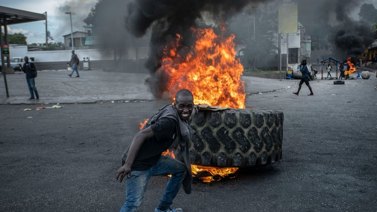 Un manifestante delante de un neumático ardiendo en una calle de Puerto Príncipe, Haití.
