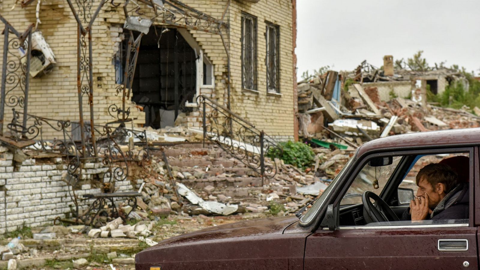 Un residente sentado en su coche en medio de la destrución por la guerra en Dolina, en Donestk (Ucrania)
