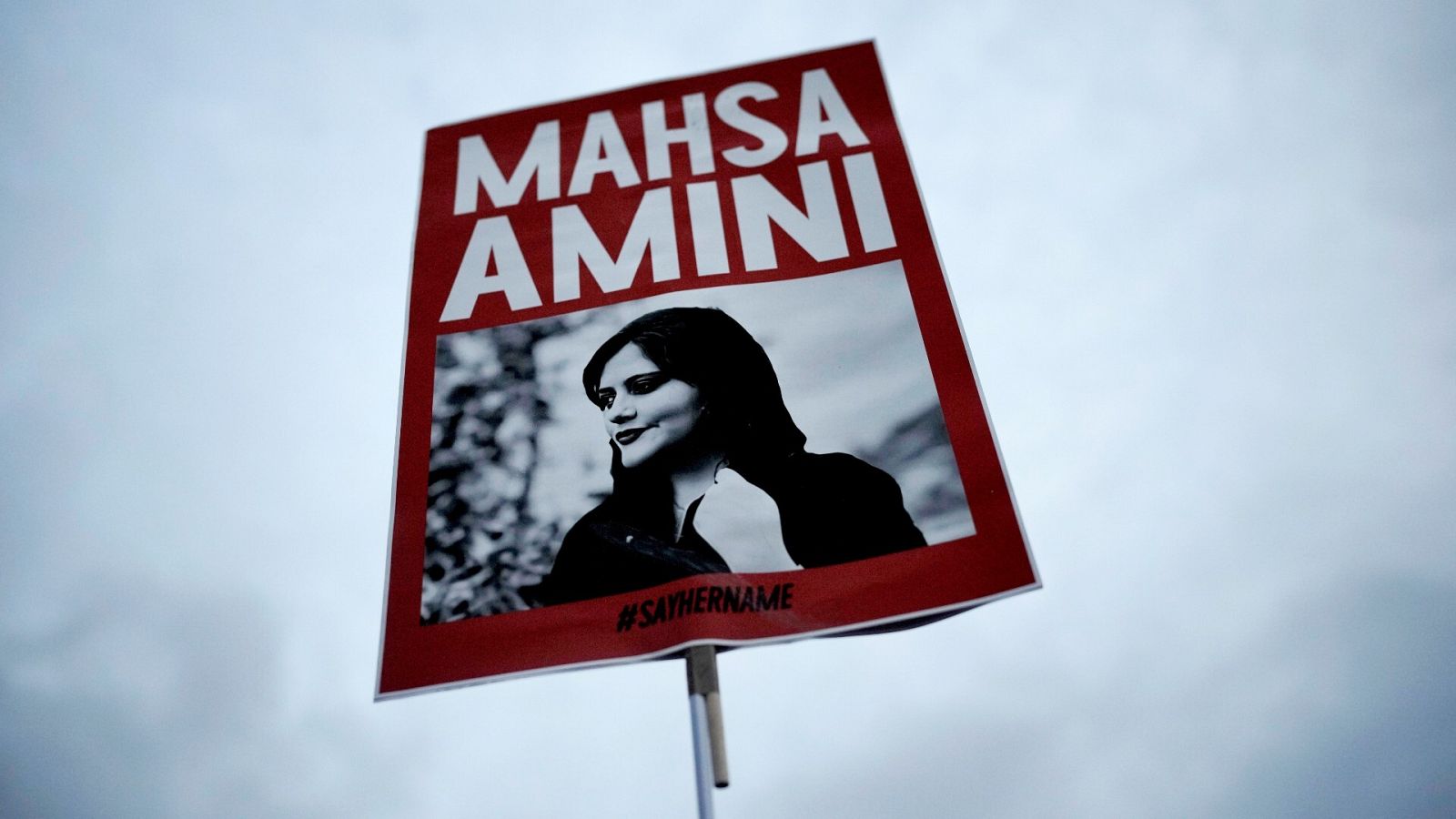 Una mujer sostiene una pancarta con una imagen de la iraní Mahsa Amini mientras asiste a una protesta contra su muerte en Berlín, Alemania