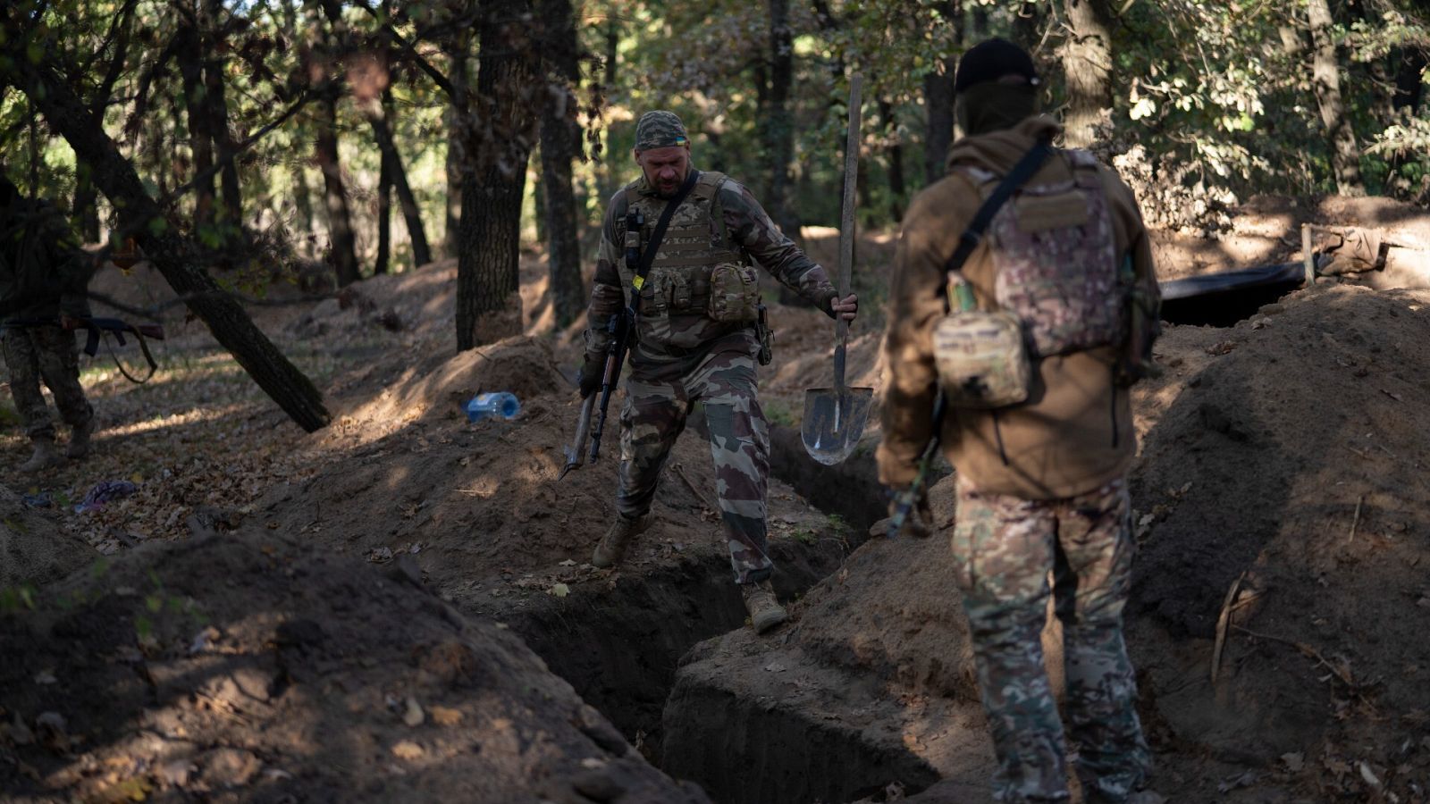 Unos soldados ucranianos cavan una trinchera