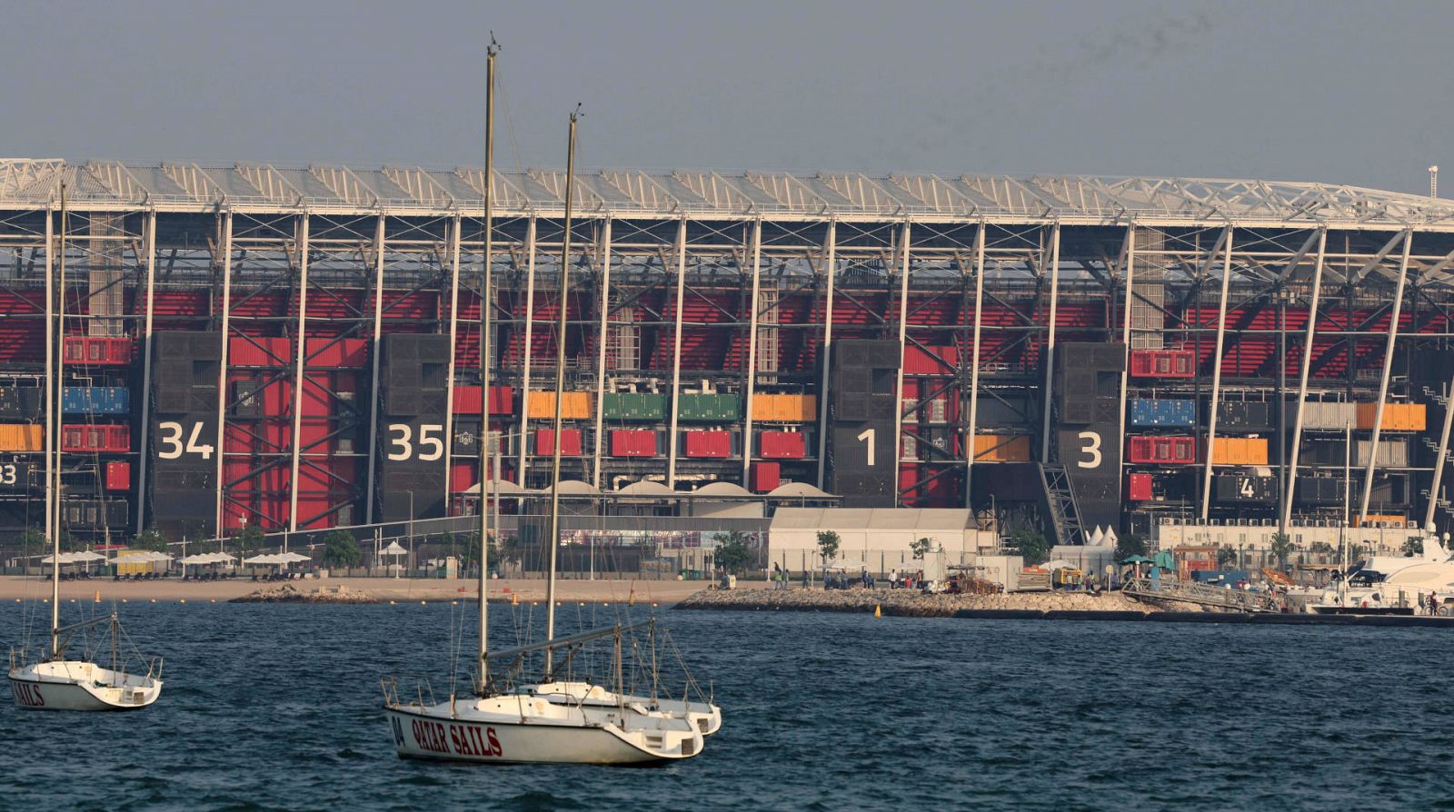 Vista del Estadio 974 del Mundial de Qatar 2022 tras el muelle de un puerto de Doha