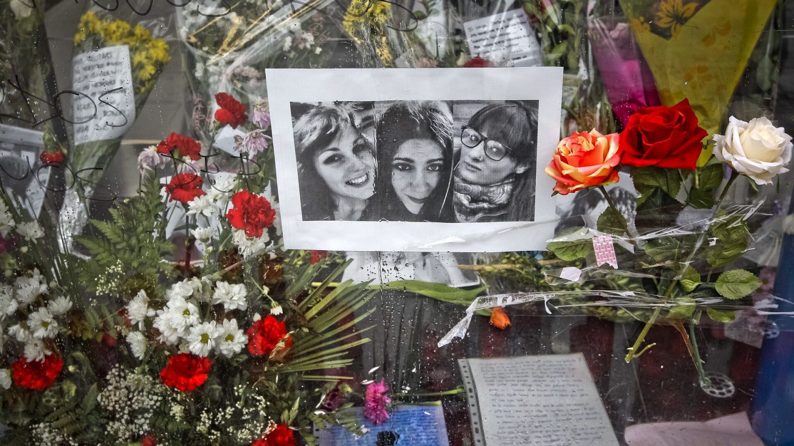 Flores junto a las fotos de tres de las cinco víctimas mortales de la tragedia del Madrid Arena