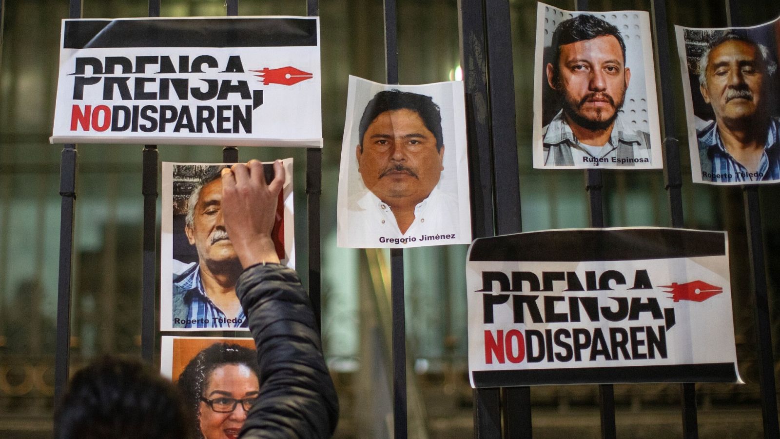 Un periodista pega una fotografía, durante una protesta el 14 de febrero de 2022, al exterior de la Secretaria de Gobernación (SG), en la Ciudad de México (México).