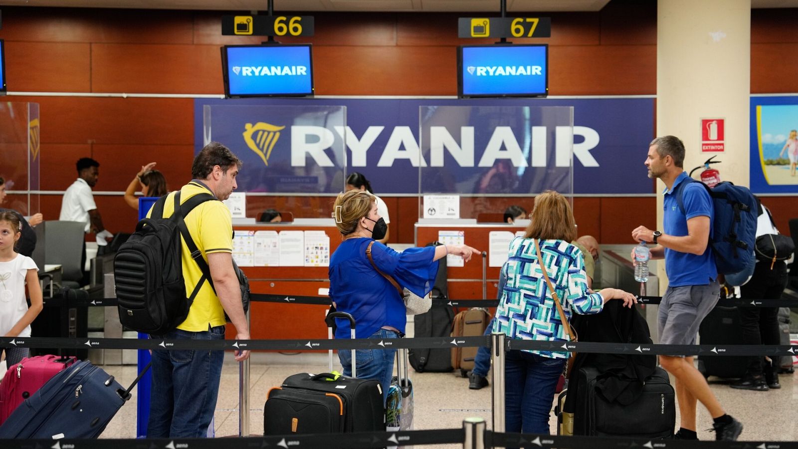 Pasajeros esperan para embarcar ante un mostrador de Ryanair