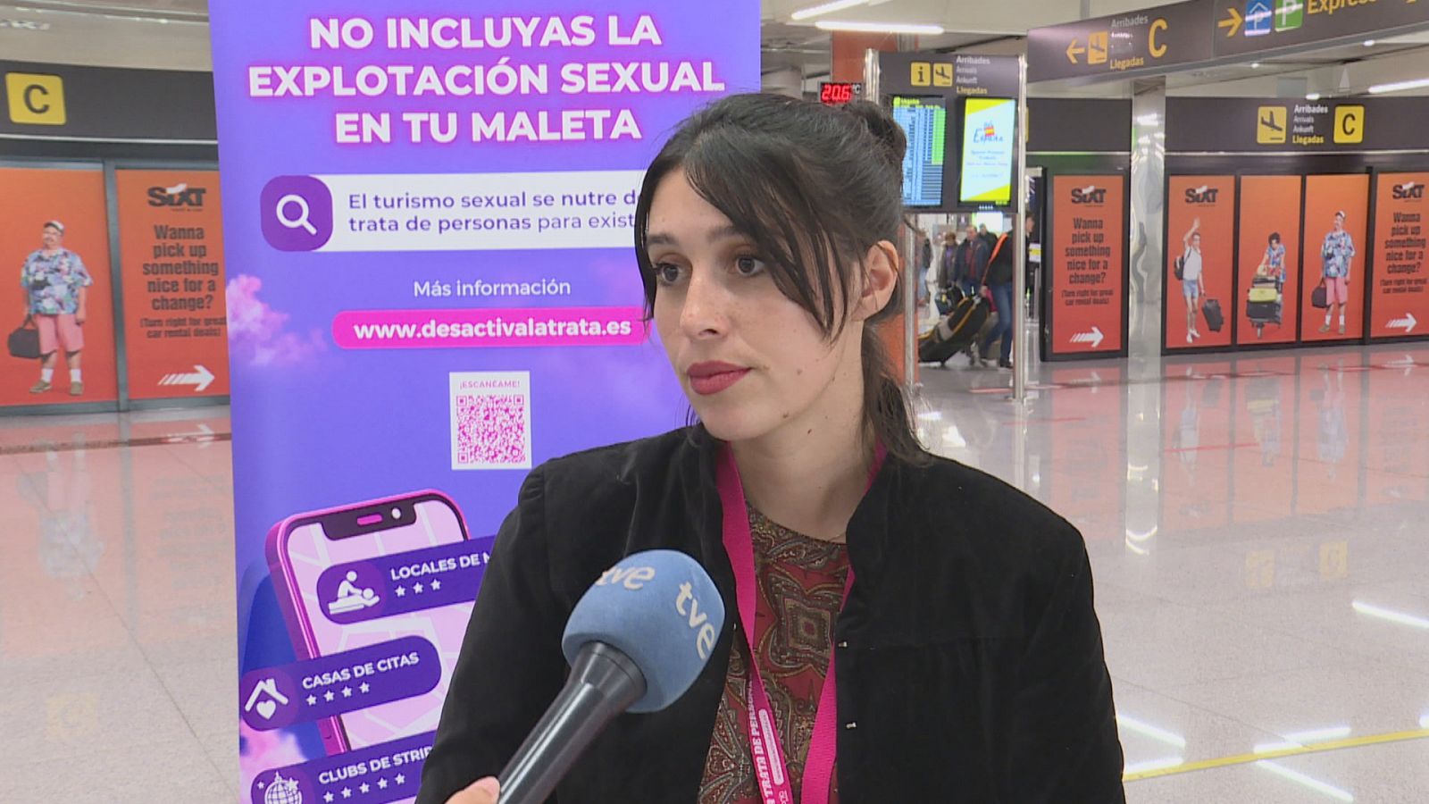 Natalia Colmenar, de Diaconía España, amb el cartell de la campanya a l'aeroport de Palma.