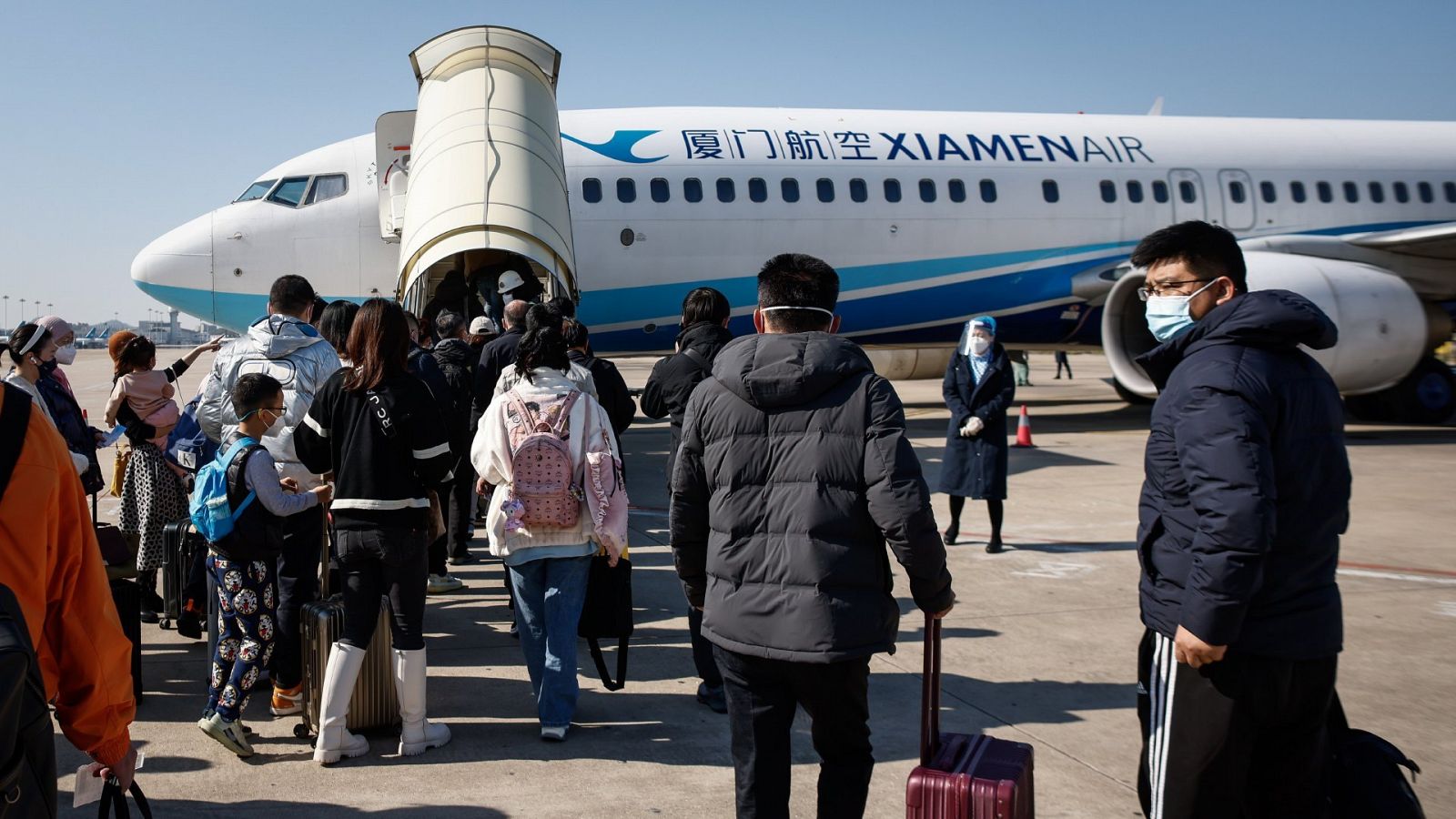 Pasajeros con destino a Pekín embarcan en un avión en el aeropuerto internacional de Xiamen Gaoqi,