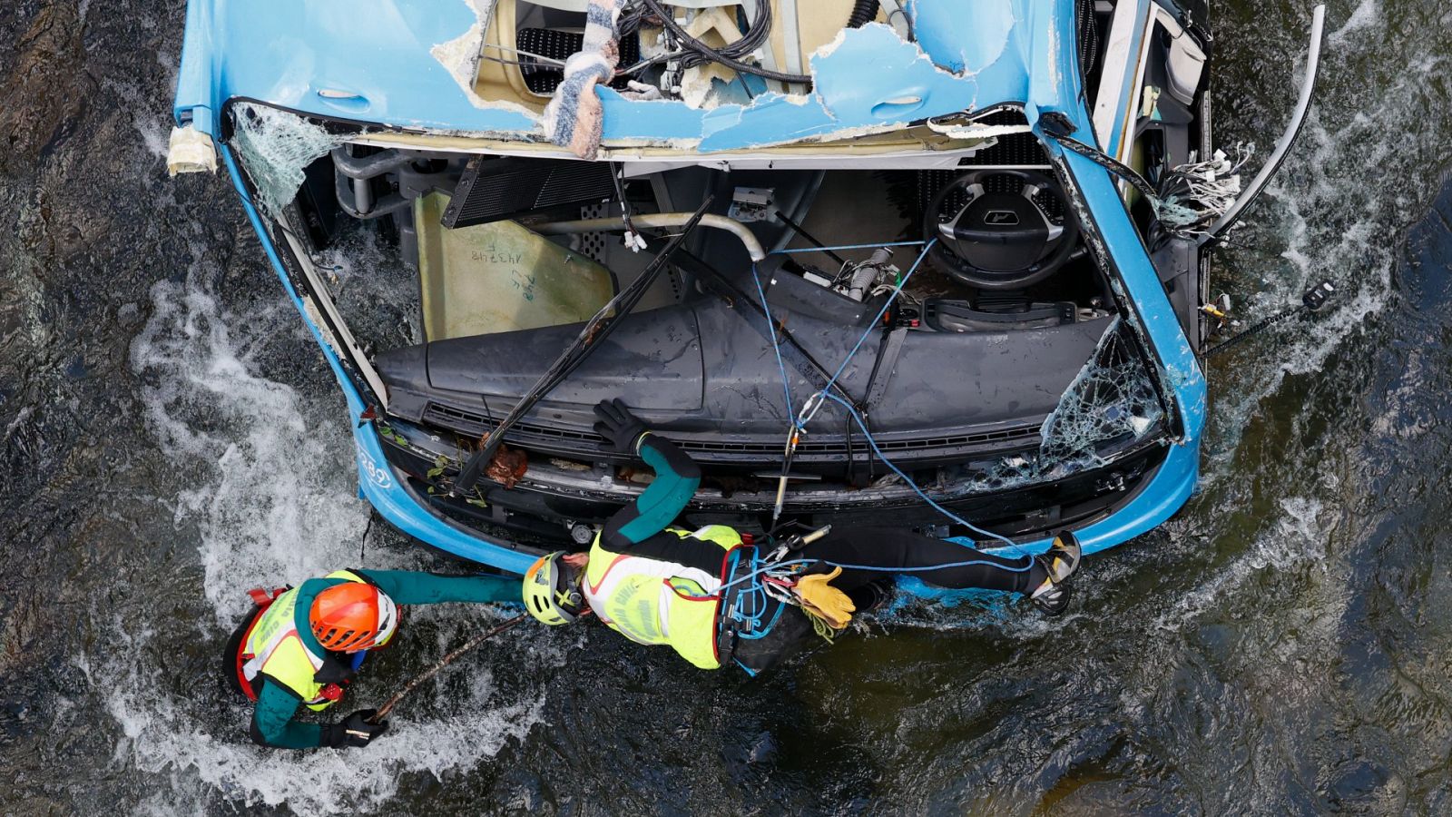 Agentes de la Guardia Civil inspeccionan el autobús para estudiar su izado desde el lecho del río Lérez, en Cerdedo